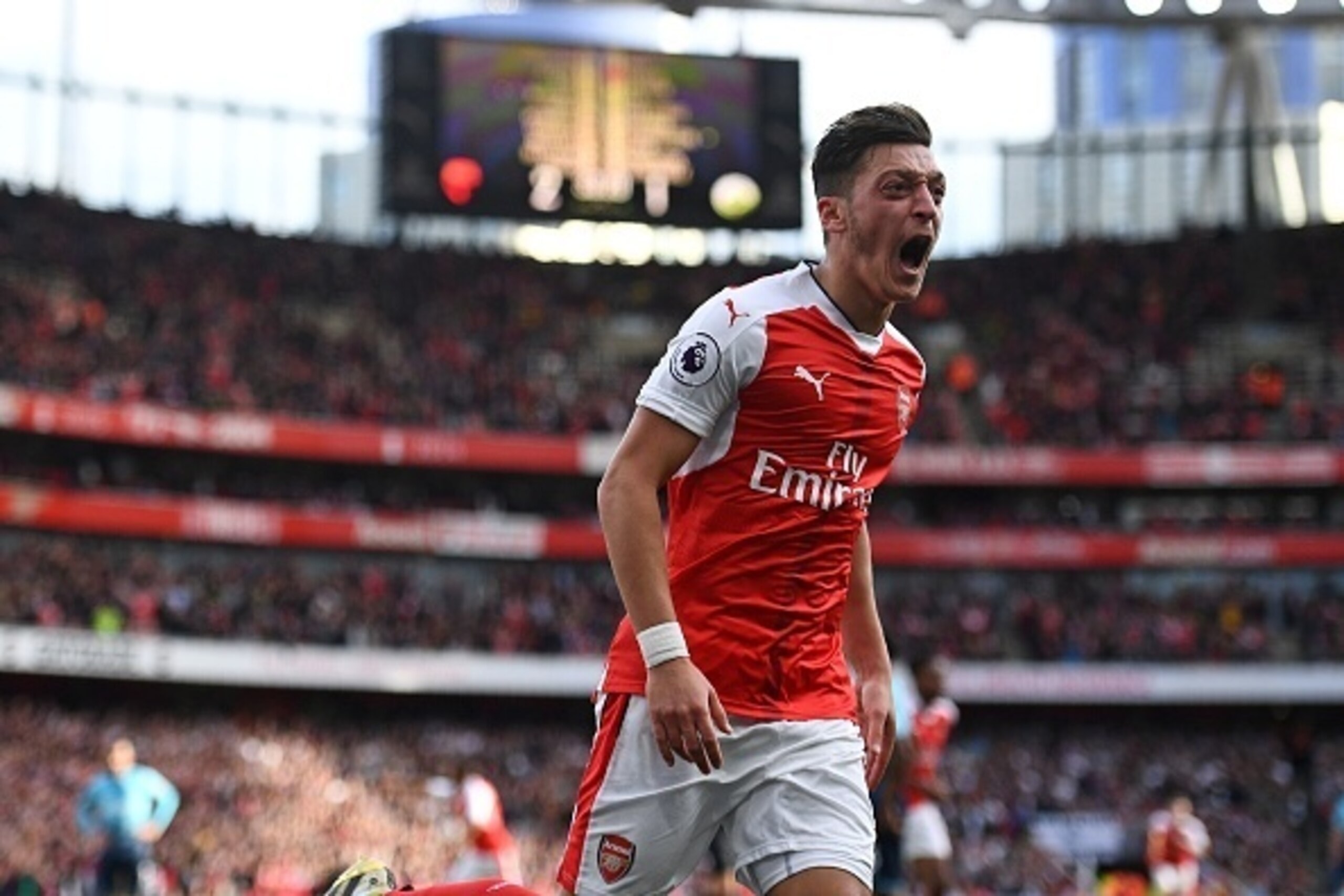 Arsenal's German midfielder Mesut Ozil celebrates after scoring their third goal during the English Premier League football match between Arsenal and Swansea City at the Emirates Stadium in London on October 15, 2016.  / AFP / Justin TALLIS / RESTRICTED T
