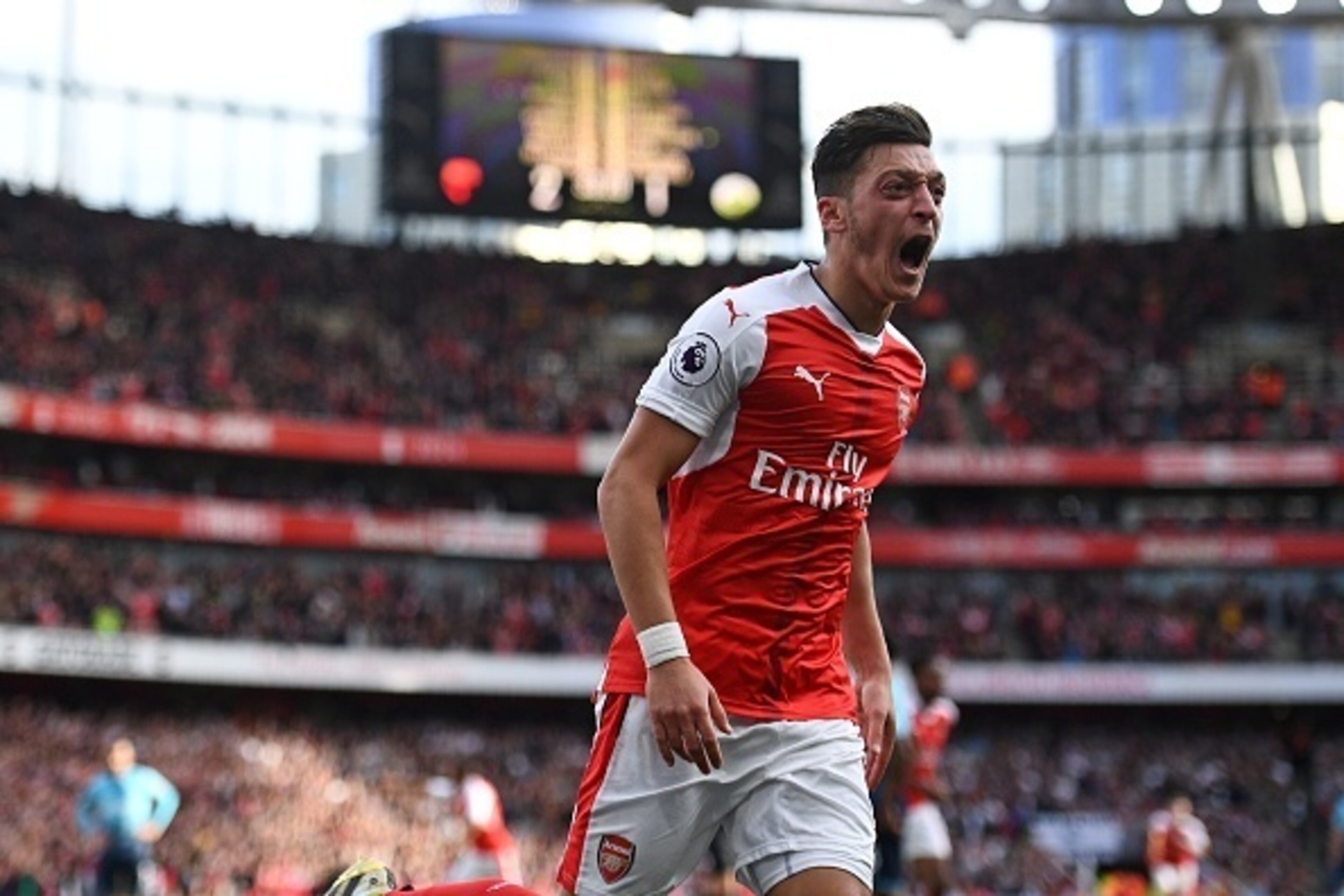 Arsenal's German midfielder Mesut Ozil celebrates after scoring their third goal during the English Premier League football match between Arsenal and Swansea City at the Emirates Stadium in London on October 15, 2016.  / AFP / Justin TALLIS / RESTRICTED T