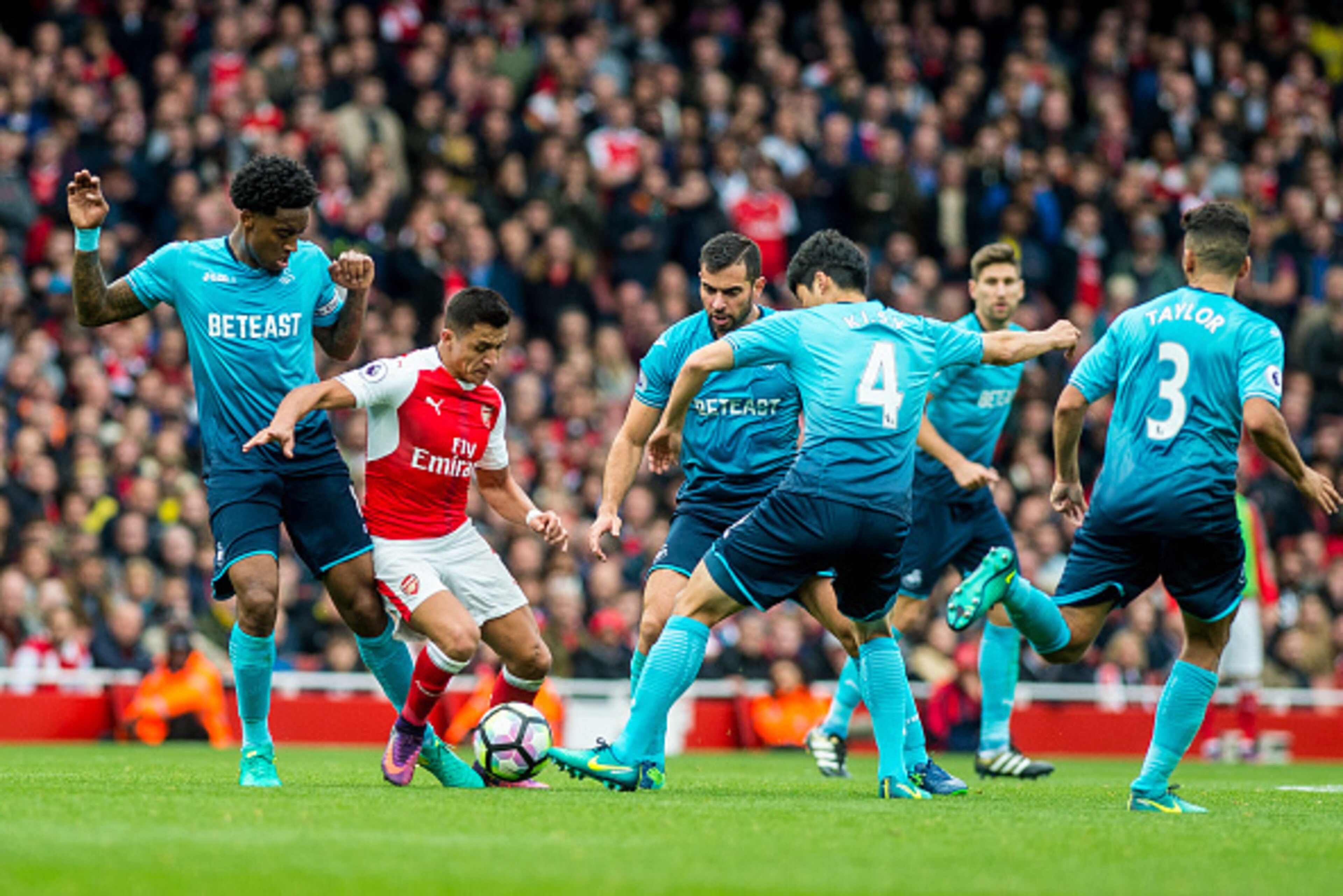 LONDON, ENGLAND - OCTOBER 15: Alexis Sanchez of Arsenal is surrounded by Swansea players during the Premier League match between Arsenal and Swansea City at Emirates Stadium on October 15, 2016 in London, England. (Photo by Athena Pictures/Getty Images)
