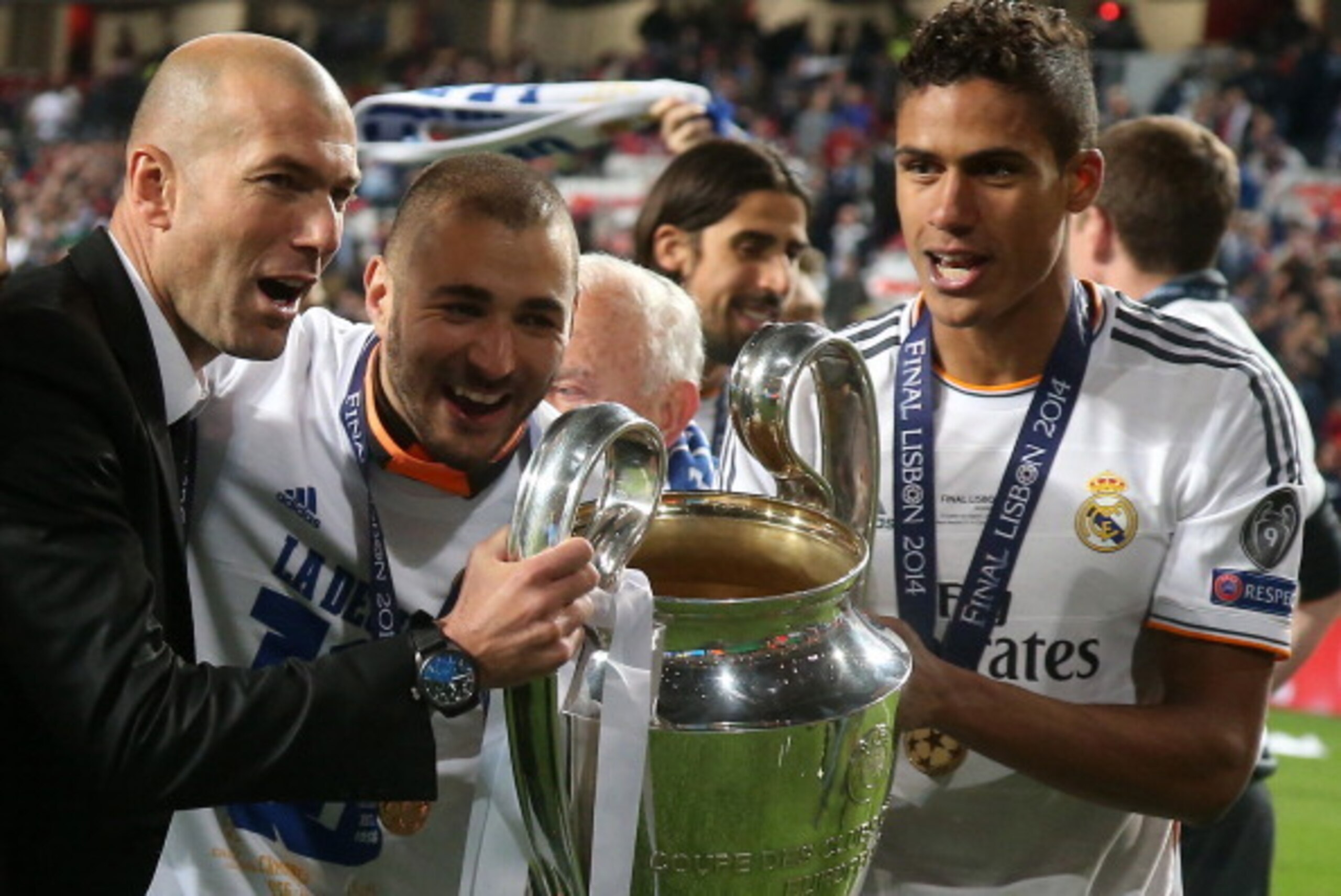 LISBON, PORTUGAL - MAY 24: Assistant-coach of Real Madrid Zinedine Zidane, Karim Benzema and Raphael Varane of Real Madrid hold the trophy after the UEFA Champions League final between Real Madrid and Atletico de Madrid at Estadio da Luz stadium on May 24