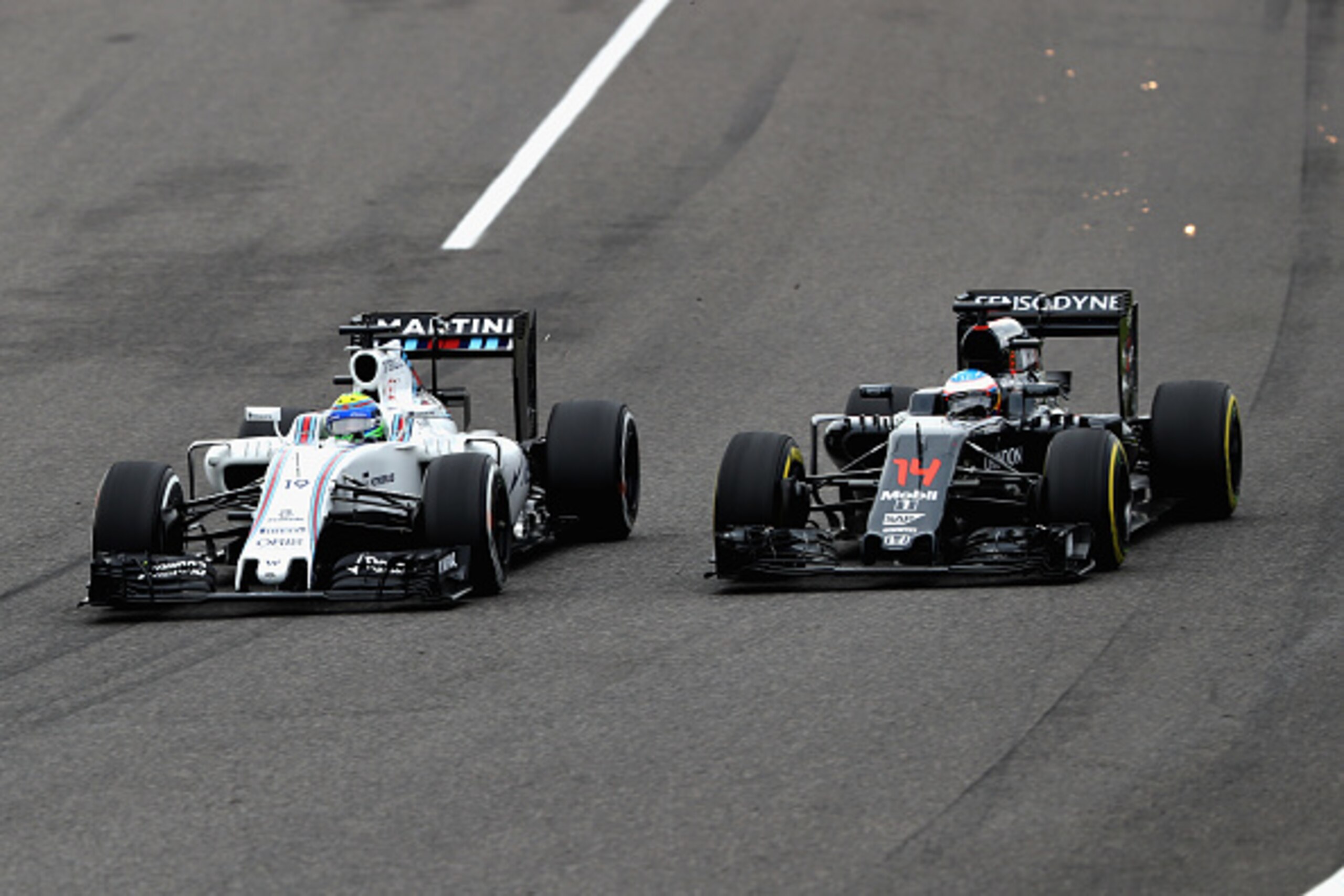 SUZUKA, JAPAN - OCTOBER 09: Felipe Massa of Brazil driving the (19) Williams Martini Racing Williams FW38 Mercedes PU106C Hybrid turbo battles with Fernando Alonso of Spain driving the (14) McLaren Honda Formula 1 Team McLaren MP4-31 Honda RA616H Hybrid t