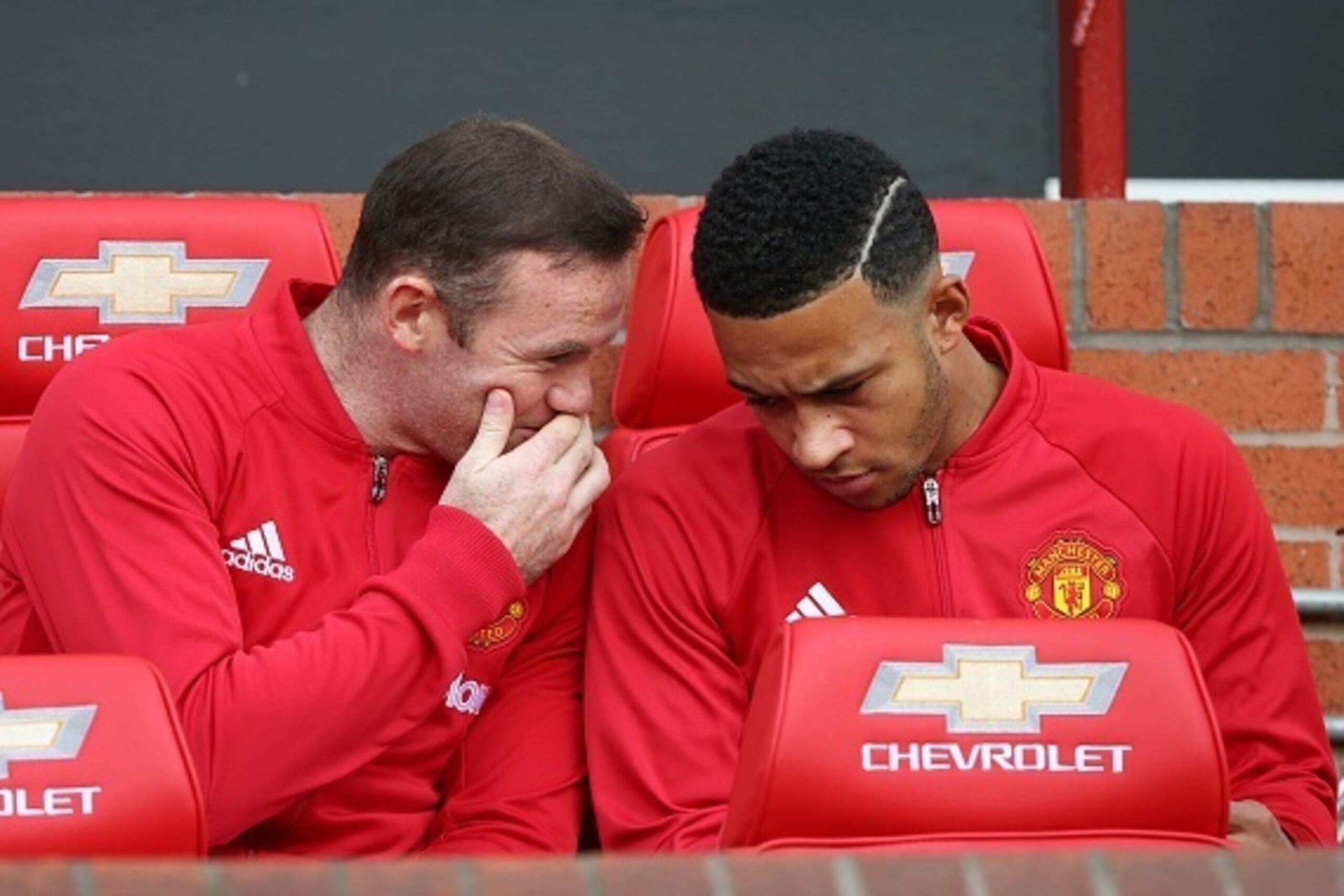 Substitute, Manchester United's English striker Wayne Rooney, talks to Manchester United's Dutch midfielder Memphis Depay (R) on the bench ahead of the English Premier League football match between Manchester United and Stoke City at Old Trafford in Manch