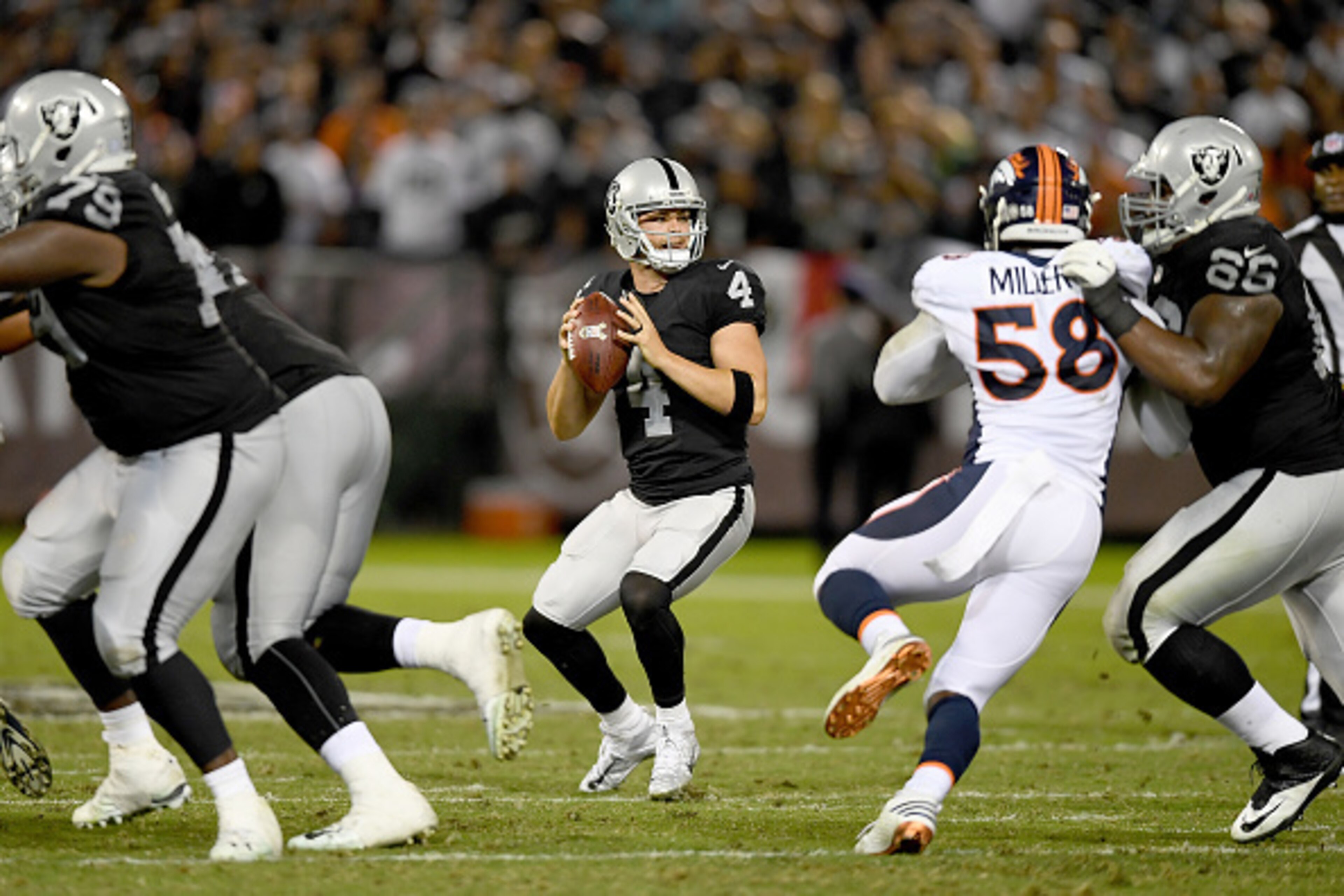 OAKLAND, CA - NOVEMBER 06:  Derek Carr #4 of the Oakland Raiders drops back to pass against the Denver Broncos in the second quarter of an NFL football game at the Oakland-Alameda County Coliseum on November 6, 2016 in Oakland, California.  (Photo by Thea