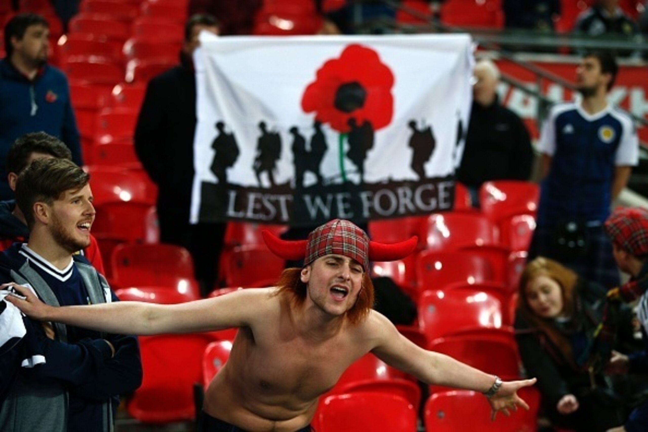 A Scottish supporter sings in front of a flag with a poppy symbol to represent the war dead before a World Cup 2018 qualification match between England and Scotland at Wembley stadium in London on November 11, 2016.
The football associations of both count