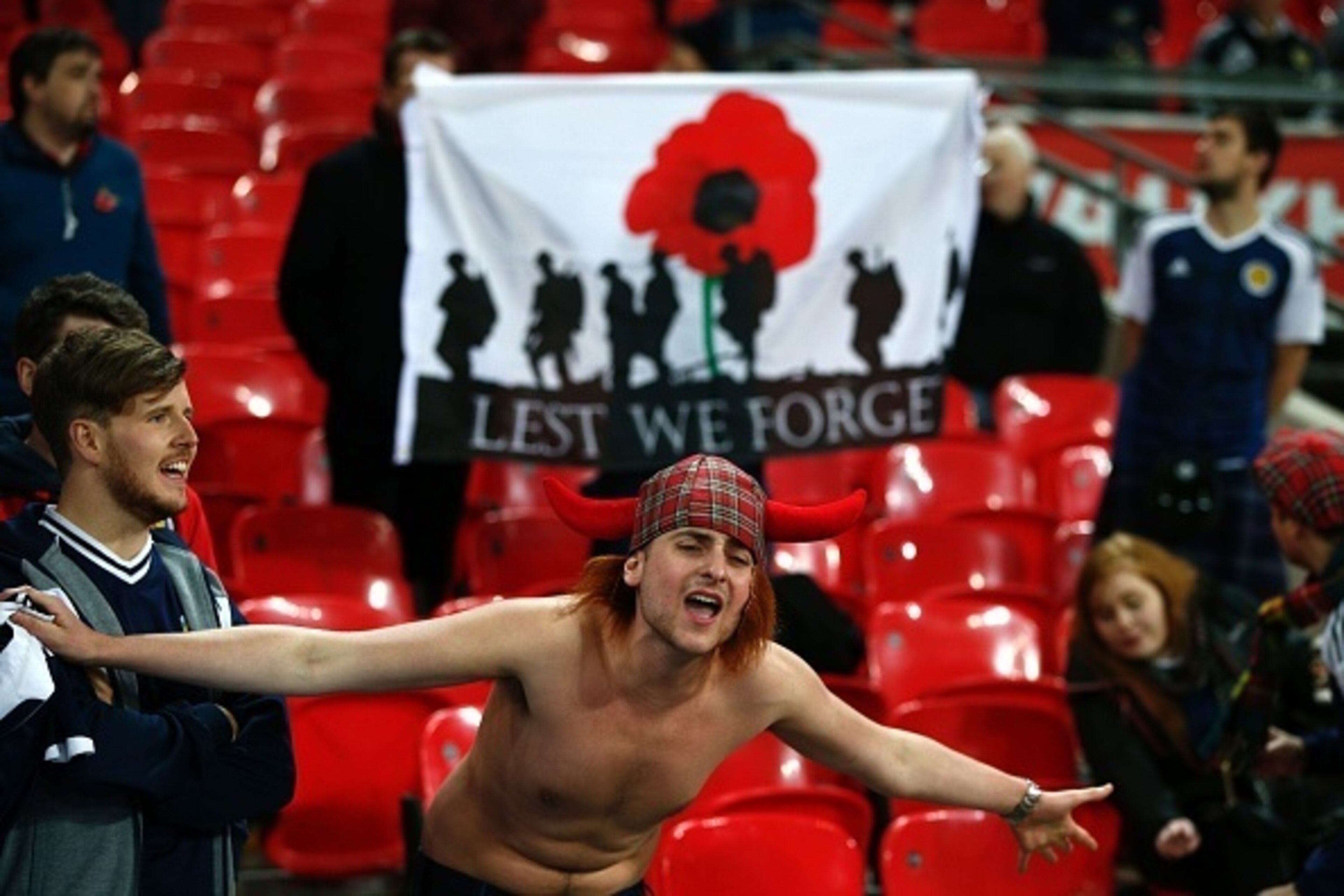 A Scottish supporter sings in front of a flag with a poppy symbol to represent the war dead before a World Cup 2018 qualification match between England and Scotland at Wembley stadium in London on November 11, 2016.
The football associations of both count