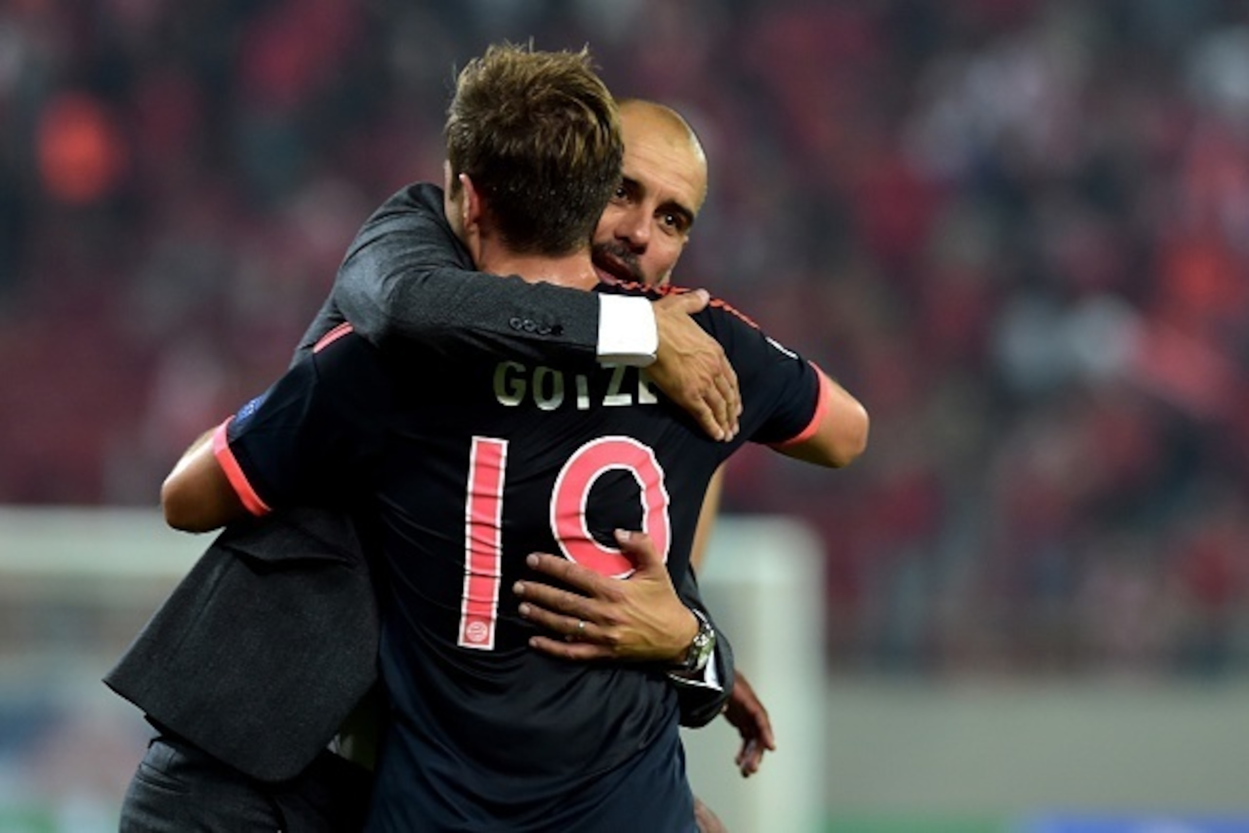 Bayern Munich's Spanish coach Josep Guardiola (rear) hugs German midfielder Mario Goetze after Bayern Munich won against Olympiakos during the Group F Champions League football match at the Karaiskaki stadium in Athens, on September 16, 2015. AFP PHOTO / 