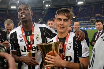 Juventus' forward from Argentina Paulo Dybala (R) and Juventus' midfielder from France Paul Pogba celebrate with the trophy after winning the Italian Tim Cup final football match AC Milan vs Juventus on May 21, 2016 at the Olympic Stadium in Rome.  Juvent