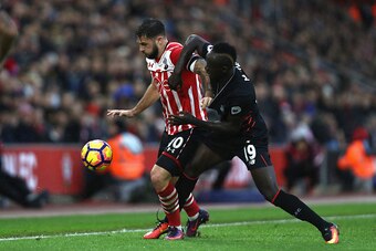 SOUTHAMPTON, ENGLAND - NOVEMBER 19: Charlie Austin of Southampton (L) and Sadio Mane of Liverpool (R) battle for possession during the Premier League match between Southampton and Liverpool at St Mary's Stadium on November 19, 2016 in Southampton, England