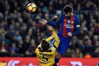 Barcelona's defender Gerard Pique (R)heads the ball past Malaga's midfielder Mikel during the Spanish league football match FC Barcelona vs Malaga CF at the Camp Nou stadium in Barcelona, on November 19, 2016. / AFP / LLUIS GENE        (Photo credit shoul