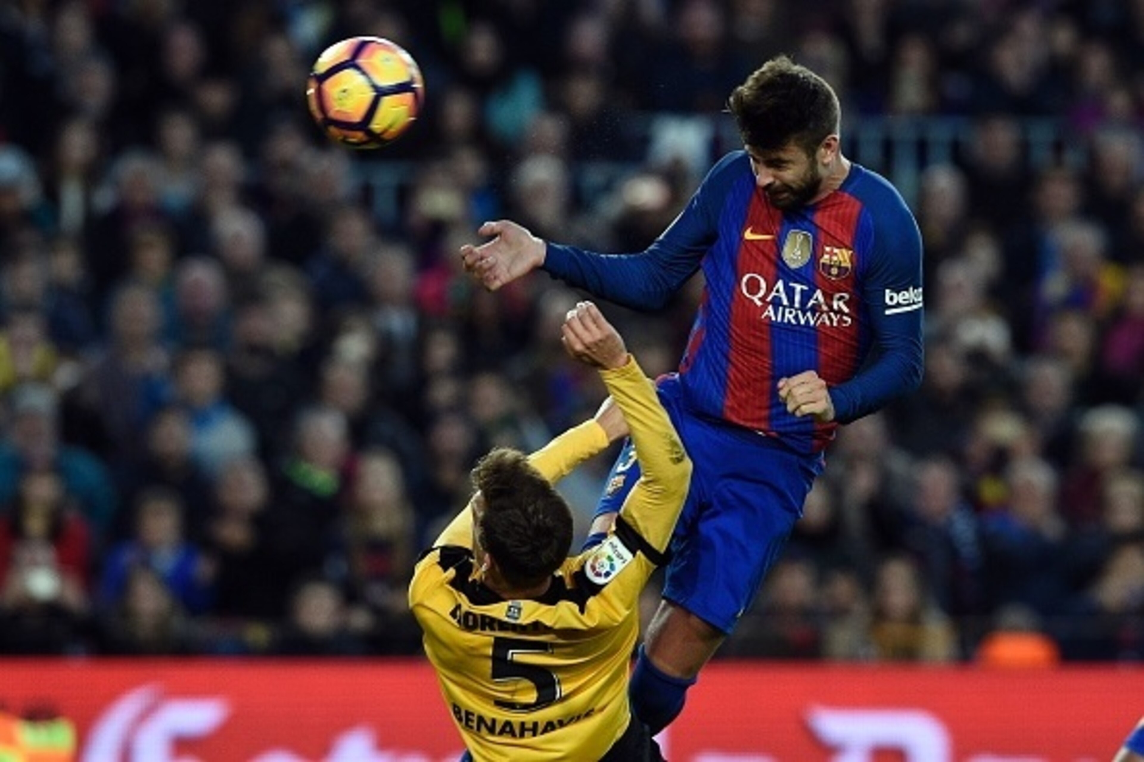 Barcelona's defender Gerard Pique (R)heads the ball past Malaga's midfielder Mikel during the Spanish league football match FC Barcelona vs Malaga CF at the Camp Nou stadium in Barcelona, on November 19, 2016. / AFP / LLUIS GENE        (Photo credit shoul