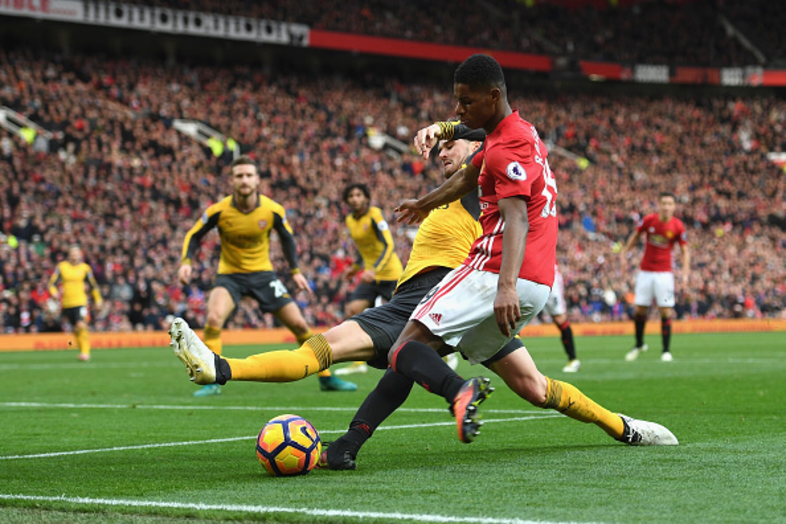 MANCHESTER, ENGLAND - NOVEMBER 19:  Carl Jenkinson of Arsenal (L) attempts to tackle Marcus Rashford of Manchester United (R) during the Premier League match between Manchester United and Arsenal at Old Trafford on November 19, 2016 in Manchester, England