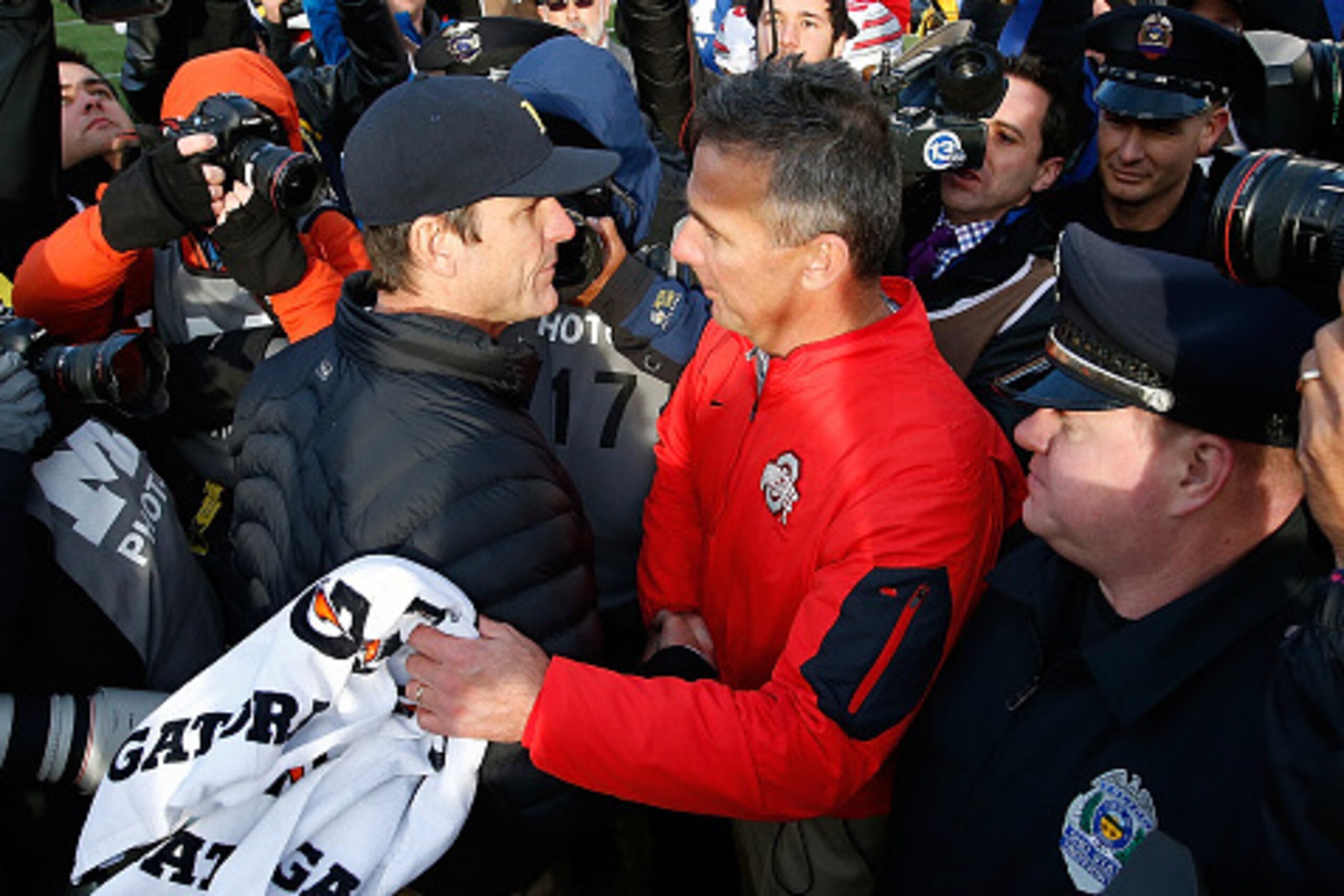ANN ARBOR, MI - NOVEMBER 28:  Head coach Urban Meyer of the Ohio State Buckeyes shakes hands with head coach Jim Harbaugh of the Michigan Wolverines after a 42-13 Ohio State win at Michigan Stadium on November 28, 2015 in Ann Arbor, Michigan.  (Photo by G