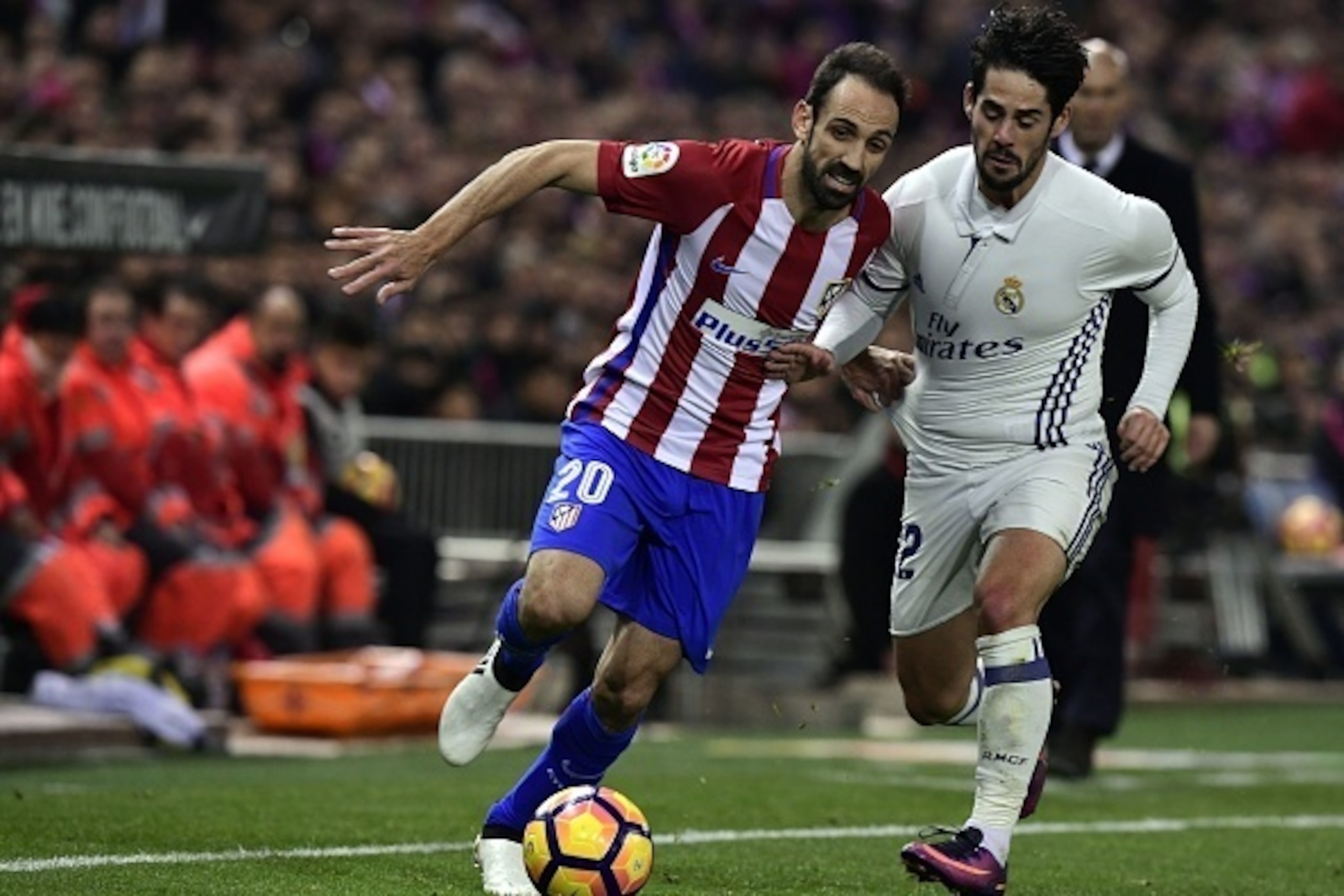 Atletico Madrid's defender Juanfran (L) vies with Real Madrid's midfielder Isco during the Spanish league football match between Club Atletico de Madrid and Real Madrid CF at the Vicente Calderon stadium in Madrid, on November 19, 2016. / AFP / GERARD JUL
