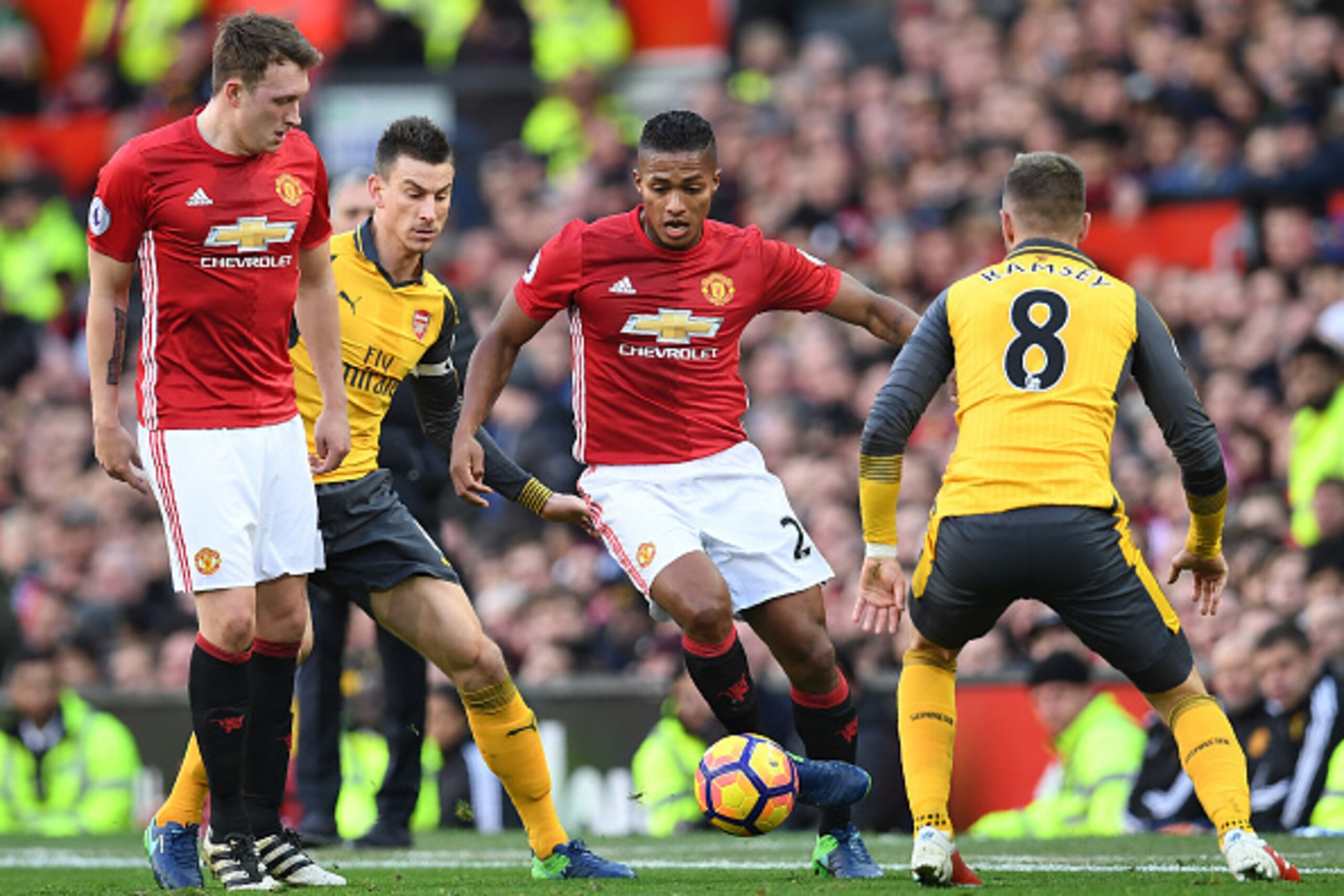 Manchester United's Ecuadorian midfielder Antonio Valencia (C) vies against Arsenal's Welsh midfielder Aaron Ramsey (R) and Arsenal's French defender Laurent Koscielny (2L) during the English Premier League football match between Manchester United and Ars