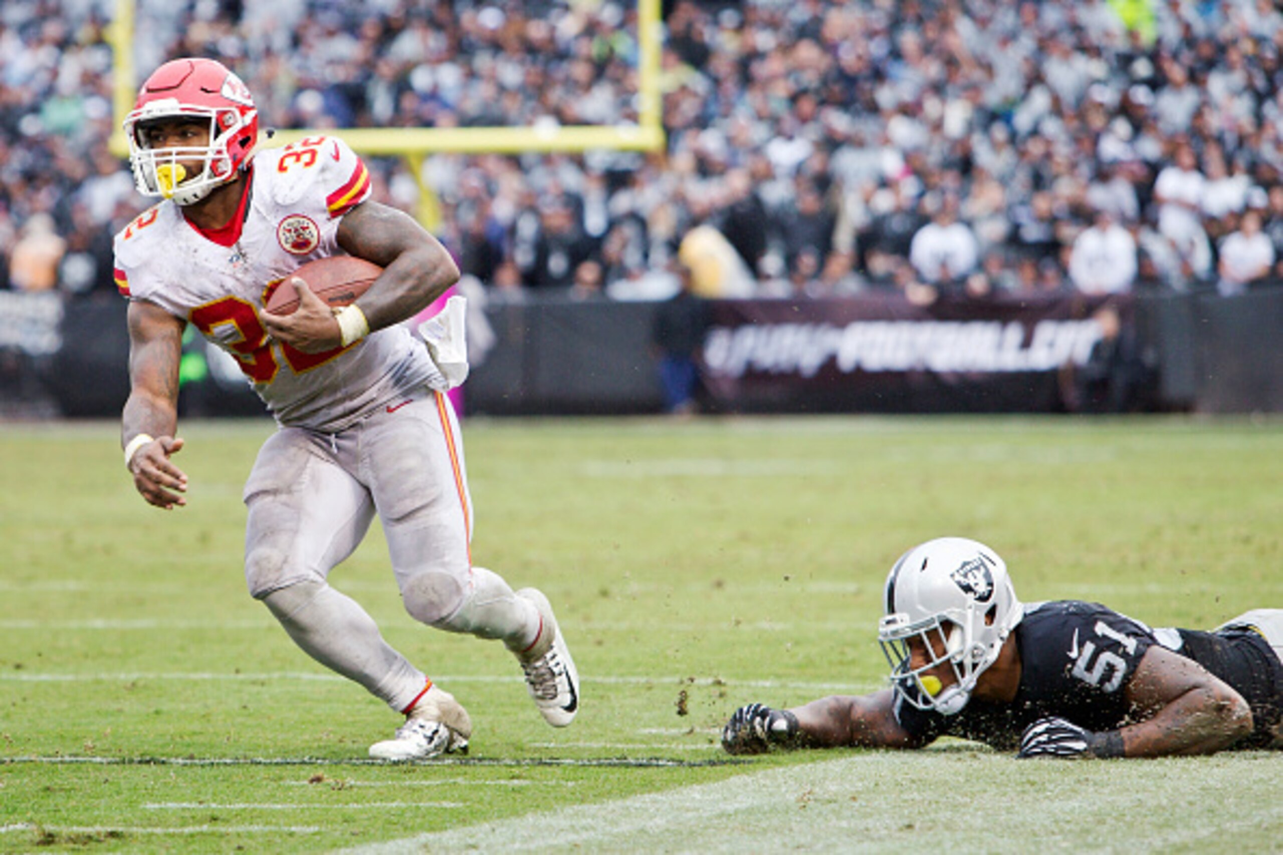 OAKLAND, CA - OCTOBER 16:  Running back Spencer Ware #32 the Kansas City Chiefs takes a short pass for 30 yards to the six yard line against outside linebacker Bruce Irvin #51 of the Oakland Raiders in the third quarter on October 16, 2016 at Oakland-Alam