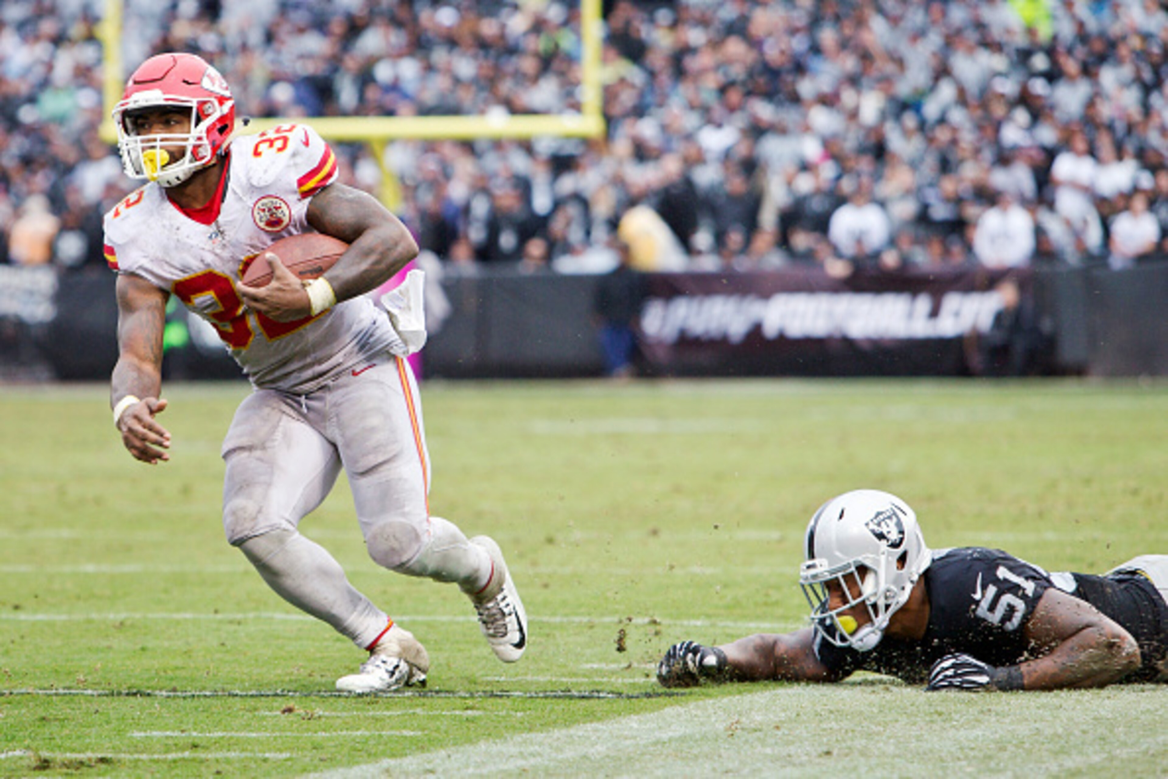 OAKLAND, CA - OCTOBER 16:  Running back Spencer Ware #32 the Kansas City Chiefs takes a short pass for 30 yards to the six yard line against outside linebacker Bruce Irvin #51 of the Oakland Raiders in the third quarter on October 16, 2016 at Oakland-Alam