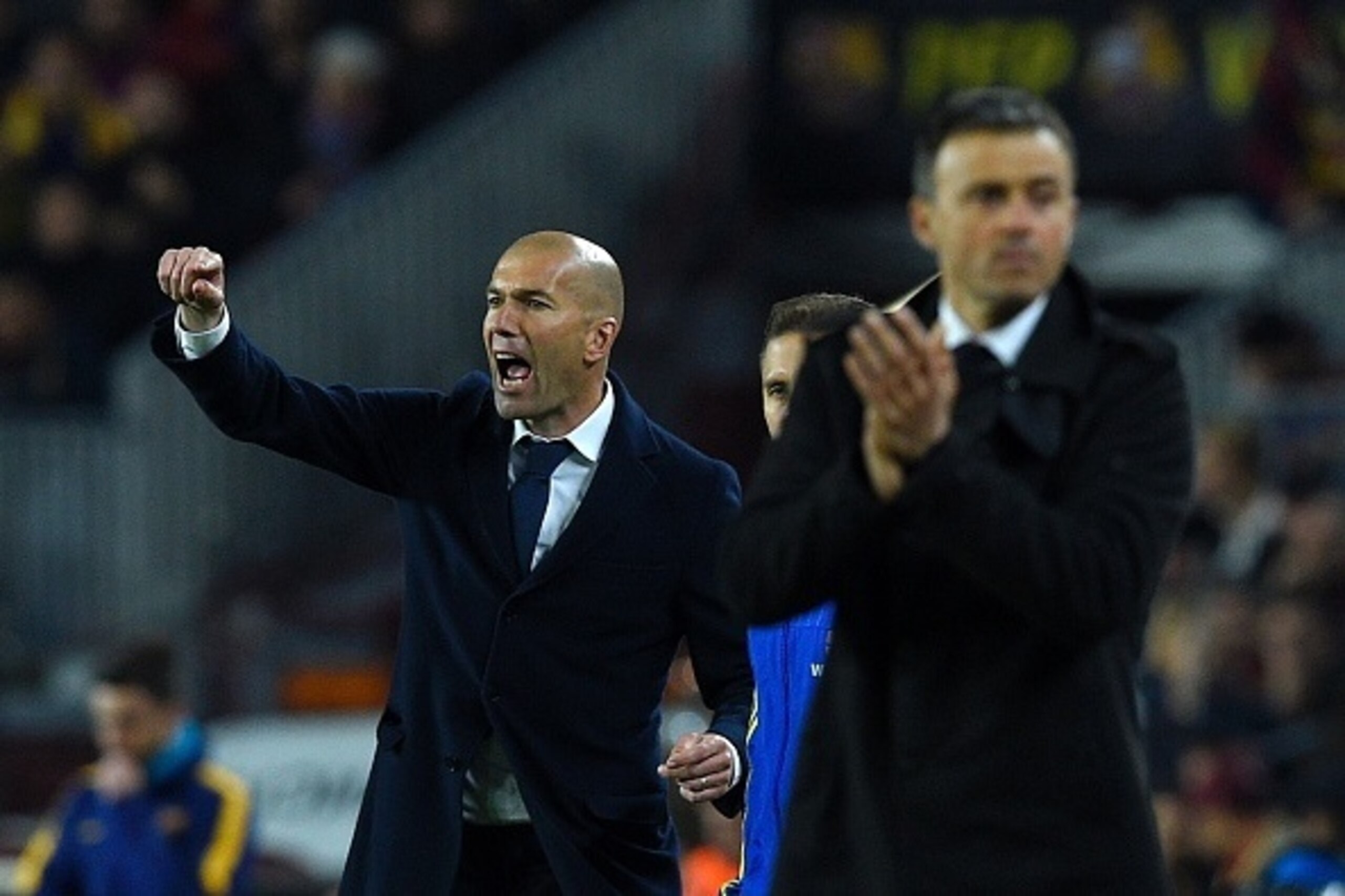 Real Madrid's French coach Zinedine Zidane (L) gives instructions to players during the Spanish league 'Clasico' football match FC Barcelona vs Real Madrid CF at the Camp Nou stadium in Barcelona on April 2, 2016. / AFP / LLUIS GENE        (Photo credit s