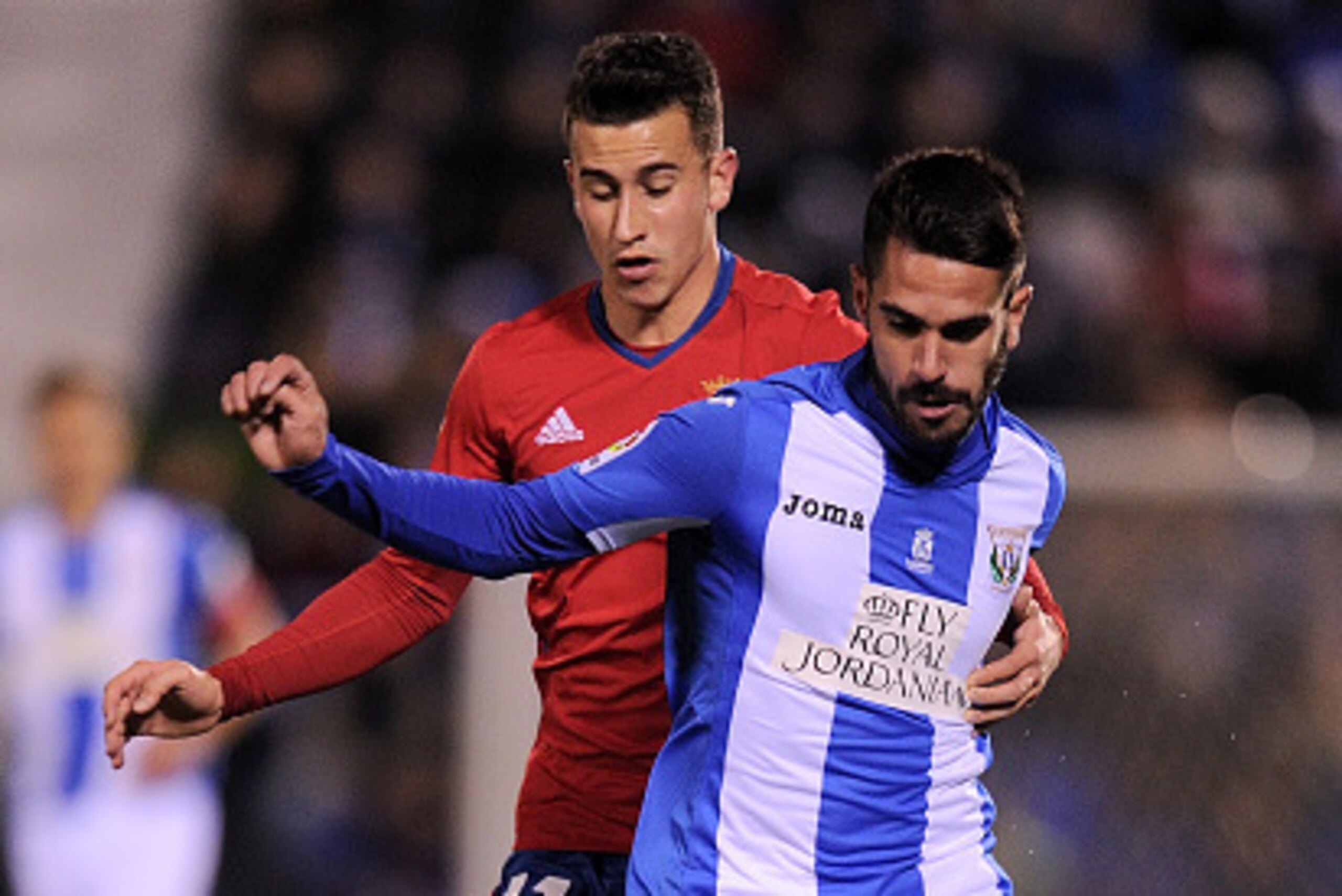 LEGANES, SPAIN - NOVEMBER 21:  Pablo Insua of CD Leganes is held by Alex Berenguer of CA Osasuna during the La Liga match between CD Leganes and CA Osasuna at Estadio Municipal de Butarque on November 21, 2016 in Leganes, Spain.  (Photo by Denis Doyle/Get