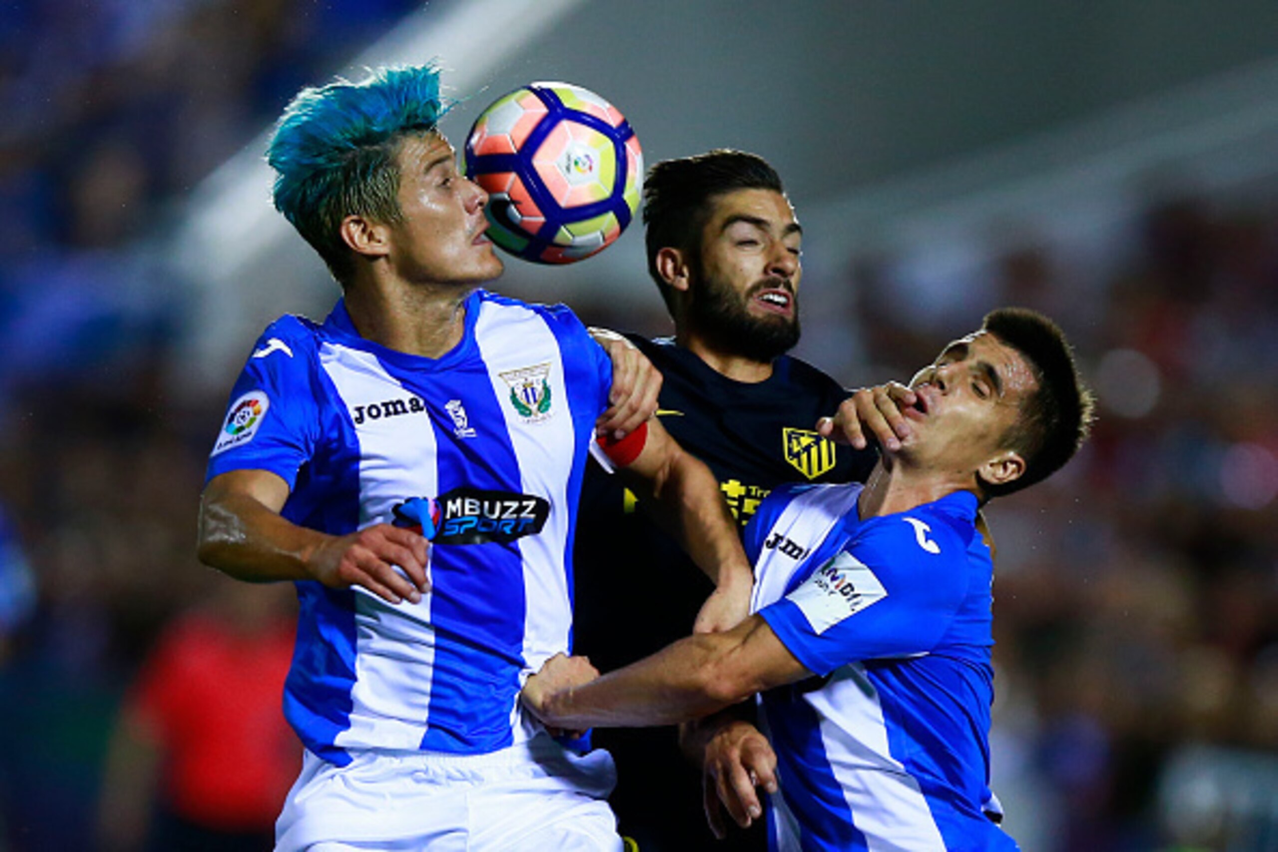 LEGANES, SPAIN - AUGUST 27: Martin M. Mantovani (L) of Deportivo Leganes wins the header after Yannick Carrasco (2ndL) of Atletico de Madrid and Unai Bustinza (R) of Deportivo Leganes during the La Liga match between Club Deportivo Leganes and Club Atleti