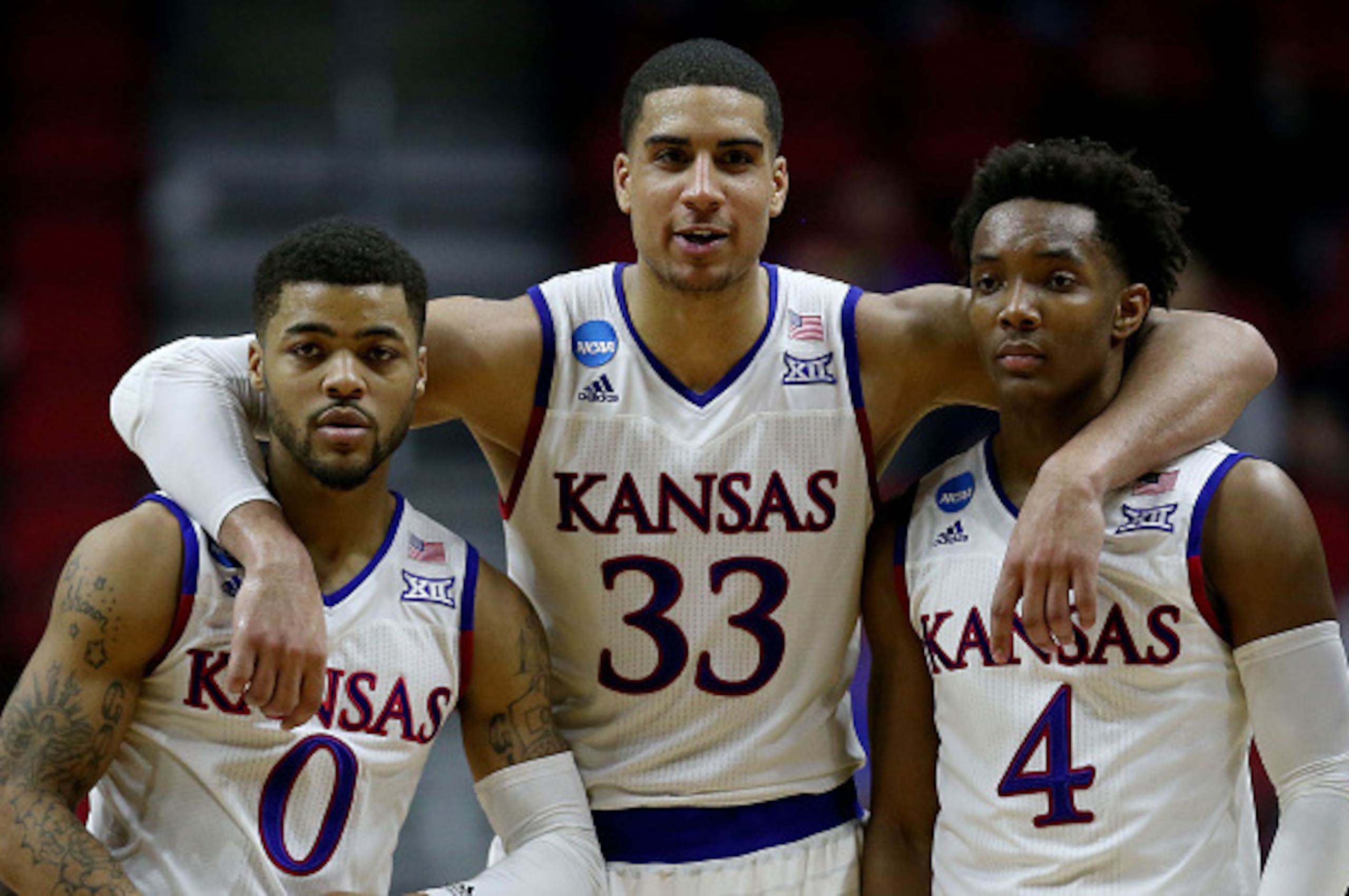 DES MOINES, IA - MARCH 19:  Frank Mason III #0 Landen Lucas #33 and Devonte' Graham #4 of the Kansas Jayhawks celebrate after defeating the Connecticut Huskies 73 to 61 during the second round of the 2016 NCAA Men's Basketball Tournament at Wells Fargo Ar