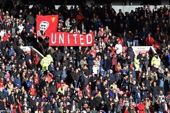 Manchester United fans hold a banner depicting Manchester United's Portuguese manager Jose Mourinho ahead of the English Premier League football match between Manchester United and Arsenal at Old Trafford in Manchester, north west England, on November 19,