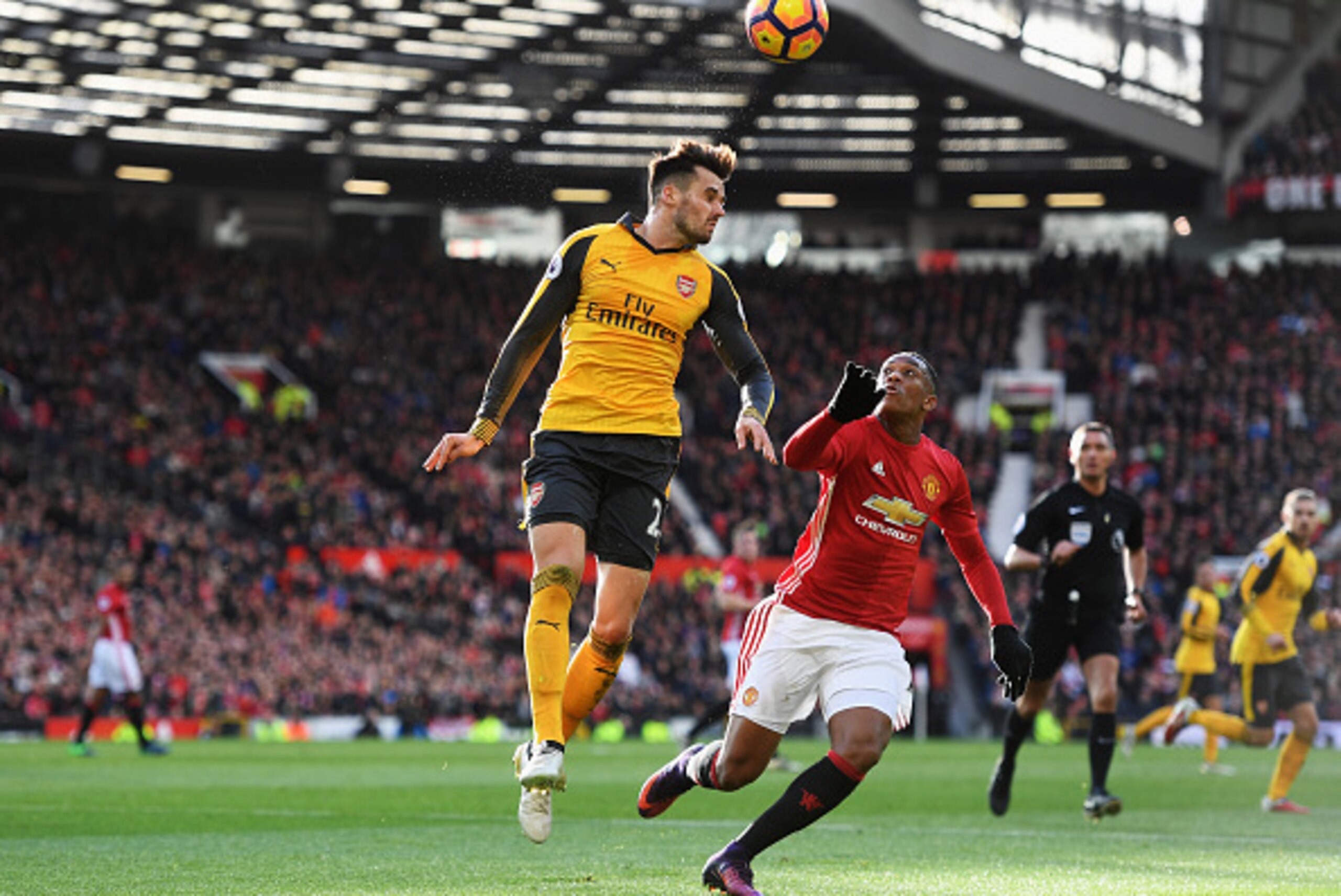 MANCHESTER, ENGLAND - NOVEMBER 19: Carl Jenkinson of Arsenal (L) wins a header over Anthony Martial of Manchester United (R) during the Premier League match between Manchester United and Arsenal at Old Trafford on November 19, 2016 in Manchester, England.