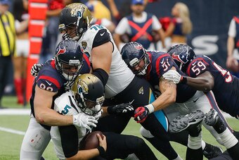 HOUSTON, TX - JANUARY 03:  Blake Bortles #5 of the Jacksonville Jaguars is sacked by J.J. Watt #99 of the Houston Texans along with John Simon #51 and Whitney Mercilus #59 as Luke Joeckel #76 of the Jacksonville Jaguars attempts to block at NRG Stadium on