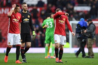 Manchester United's English striker Wayne Rooney (C) and Manchester United's Spanish goalkeeper David de Gea (2L) leave the pitch following the English Premier League football match between Manchester United and Arsenal at Old Trafford in Manchester, nort
