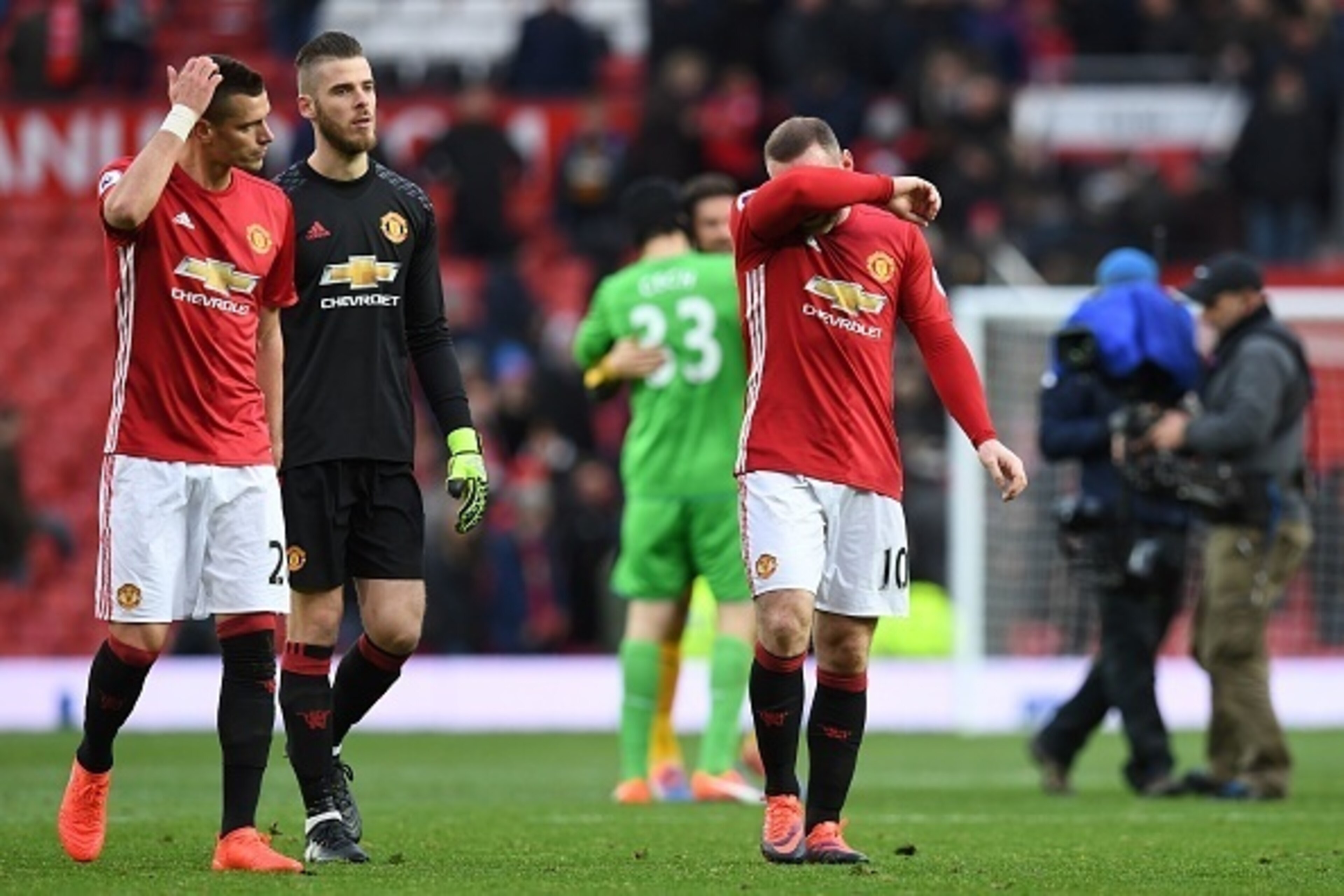 Manchester United's English striker Wayne Rooney (C) and Manchester United's Spanish goalkeeper David de Gea (2L) leave the pitch following the English Premier League football match between Manchester United and Arsenal at Old Trafford in Manchester, nort