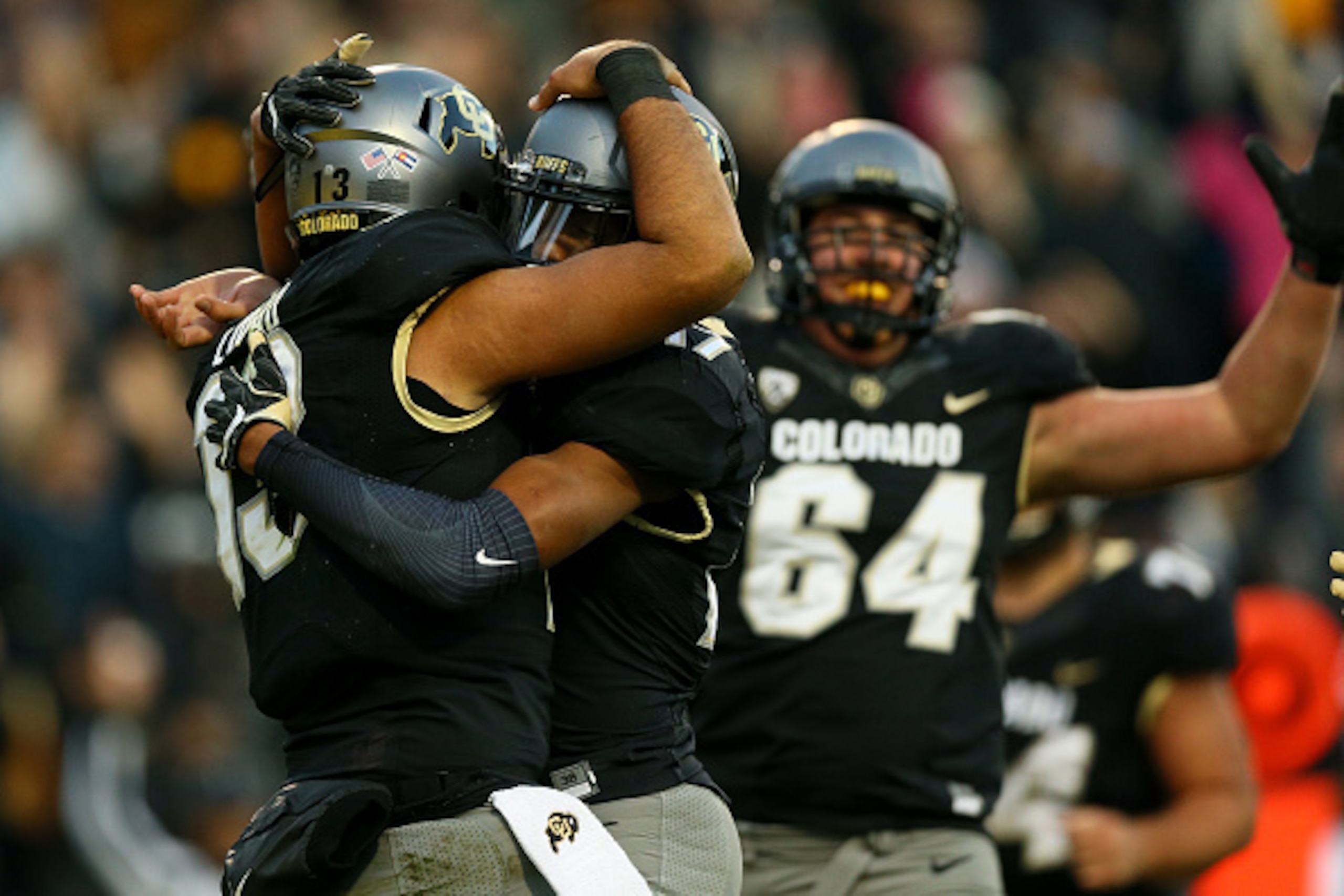 BOULDER, CO - NOVEMBER 19:  Quarterback Sefo Liufau #13 of the Colorado Buffaloes celebrates his third quarter touchdown with wide receiver Kabion Ento #17 as offensive lineman Aaron Haigler #64 runs to join in against the Washington State Cougars at Fols