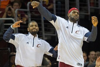 CLEVELAND, OH - OCTOBER 14: Kyrie Irving #2 and LeBron James #23 of the Cleveland Cavaliers cheer on their teammates from the bench during the second half against the Milwaukee Bucks at Quicken Loans Arena on October 14, 2014 in Cleveland, Ohio. The Caval