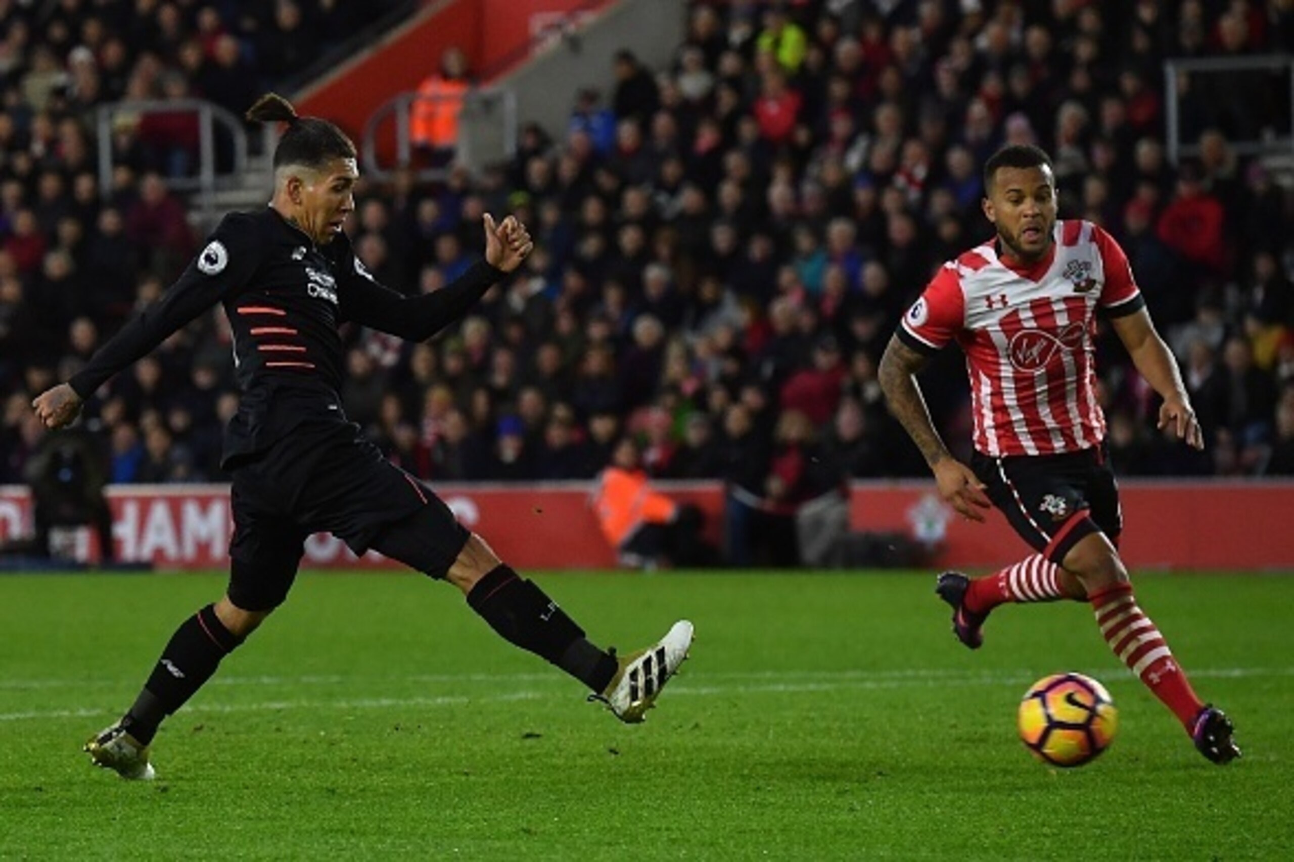 Liverpool's Brazilian midfielder Roberto Firmino (L) shoots but fails to score during the English Premier League football match between Southampton and Liverpool at St Mary's Stadium in Southampton, southern England on November 19, 2016. / AFP / BEN STANS