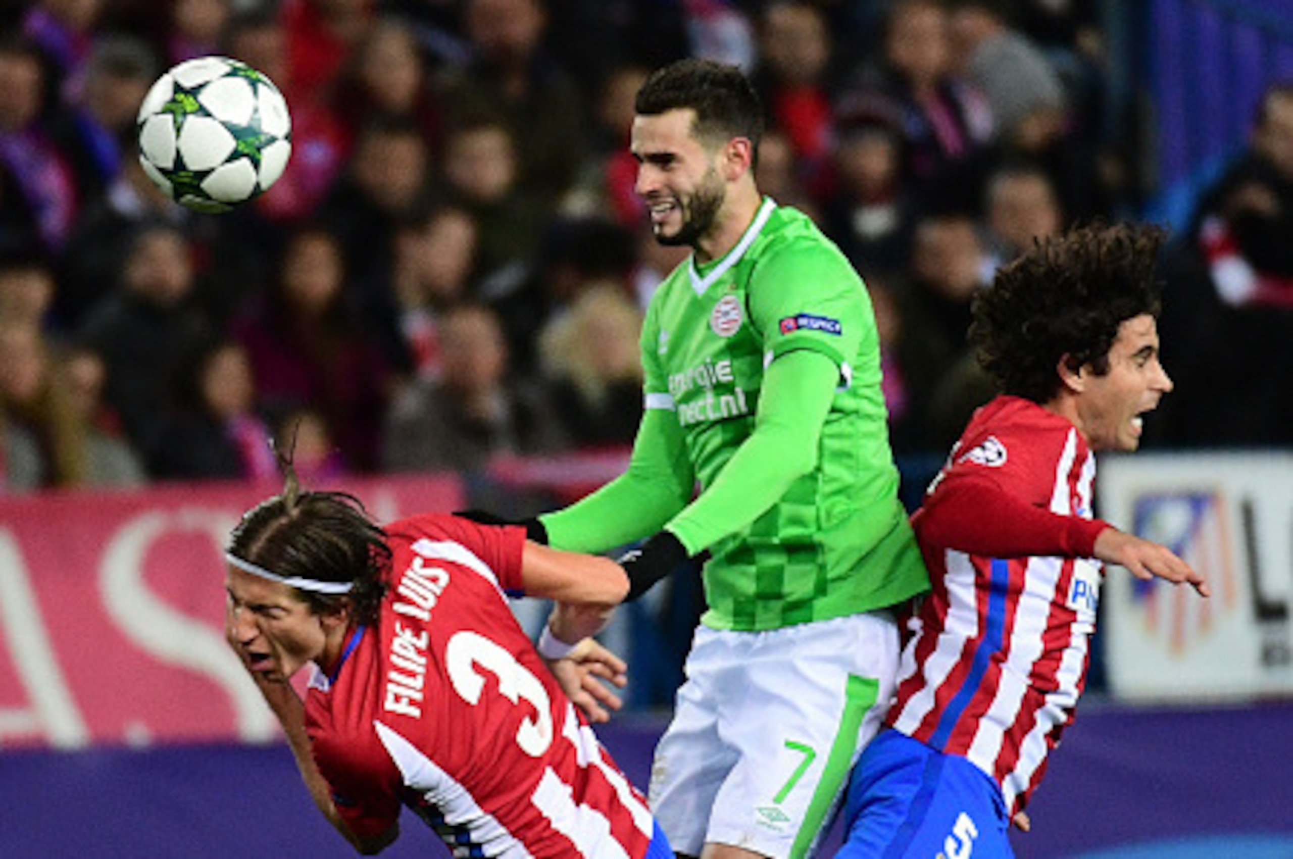 Atletico Madrid's Brazilian defender Filipe Luis (L) and Atletico Madrid's Portuguese midfielder Tiago (R) vie with PSV Eindhoven's Uruguayan forward Gaston Pereiro during the UEFA Champions League Group D football match Club Atletico de Madrid vs PSV Ein