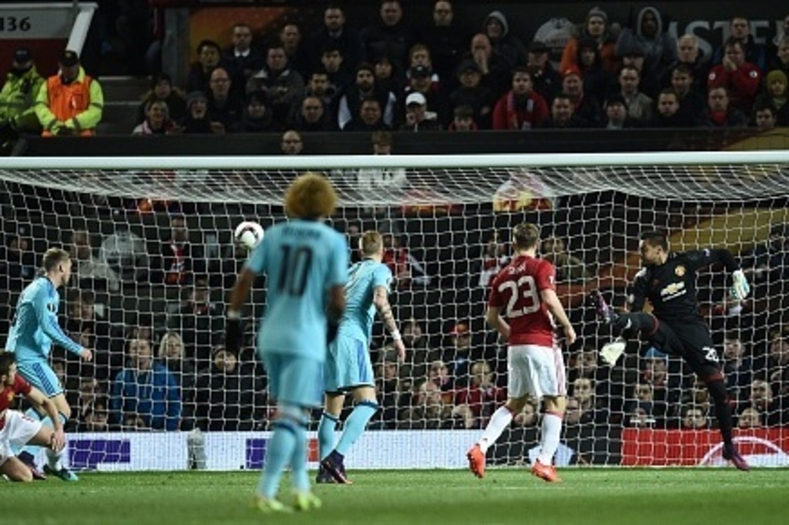 Manchester United's Argentinian goalkeeper Sergio Romero (R) flicks out his leg to make a save during the UEFA Europa League group A football match between Manchester United and Feyenoord at Old Trafford stadium in Manchester, north-west England, on Novem