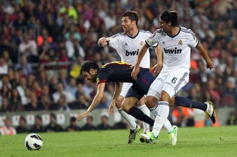 Barcelona's midfielder Cesc Fabregas (L) vies with Real Madrid's German midfielder Sami Khedira (R) and Real Madrid's midfielder Xabi Alonso during the Spanish League clasico football match FC Barcelona vs Real Madrid at the Camp Nou stadium in Barcelona 