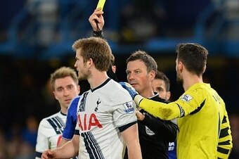 Tottenham Hotspur's English defender Eric Dier (L) is shown a yellow card by referee Mark Clattenburg (C) during the English Premier League football match between Chelsea and Tottenham Hotspur at Stamford Bridge in London on May 2, 2016. / AFP / GLYN KIRK