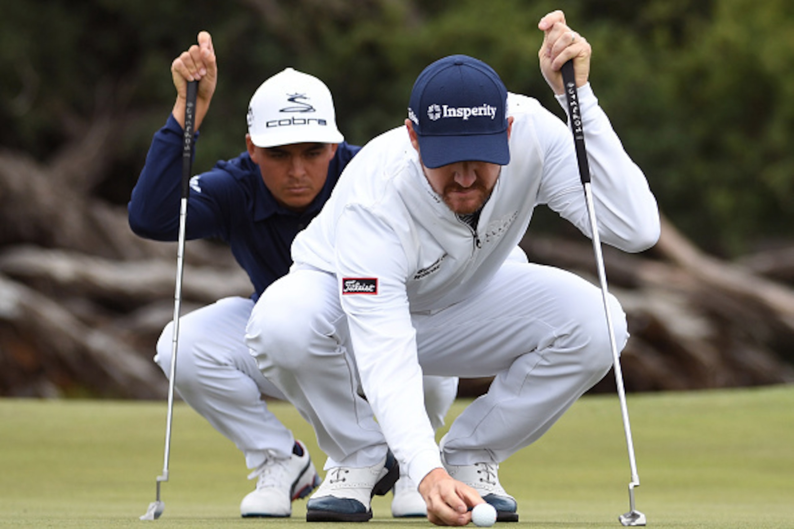 Jimmy Walker of the US (R) and teammate Rickie Fowler line up a putt during the third day of the World Cup of Golf on the Kingston Heath course in Melbourne on November 26, 2016. / AFP / William WEST / IMAGE RESTRICTED TO EDITORIAL USE - STRICTLY NO COMME