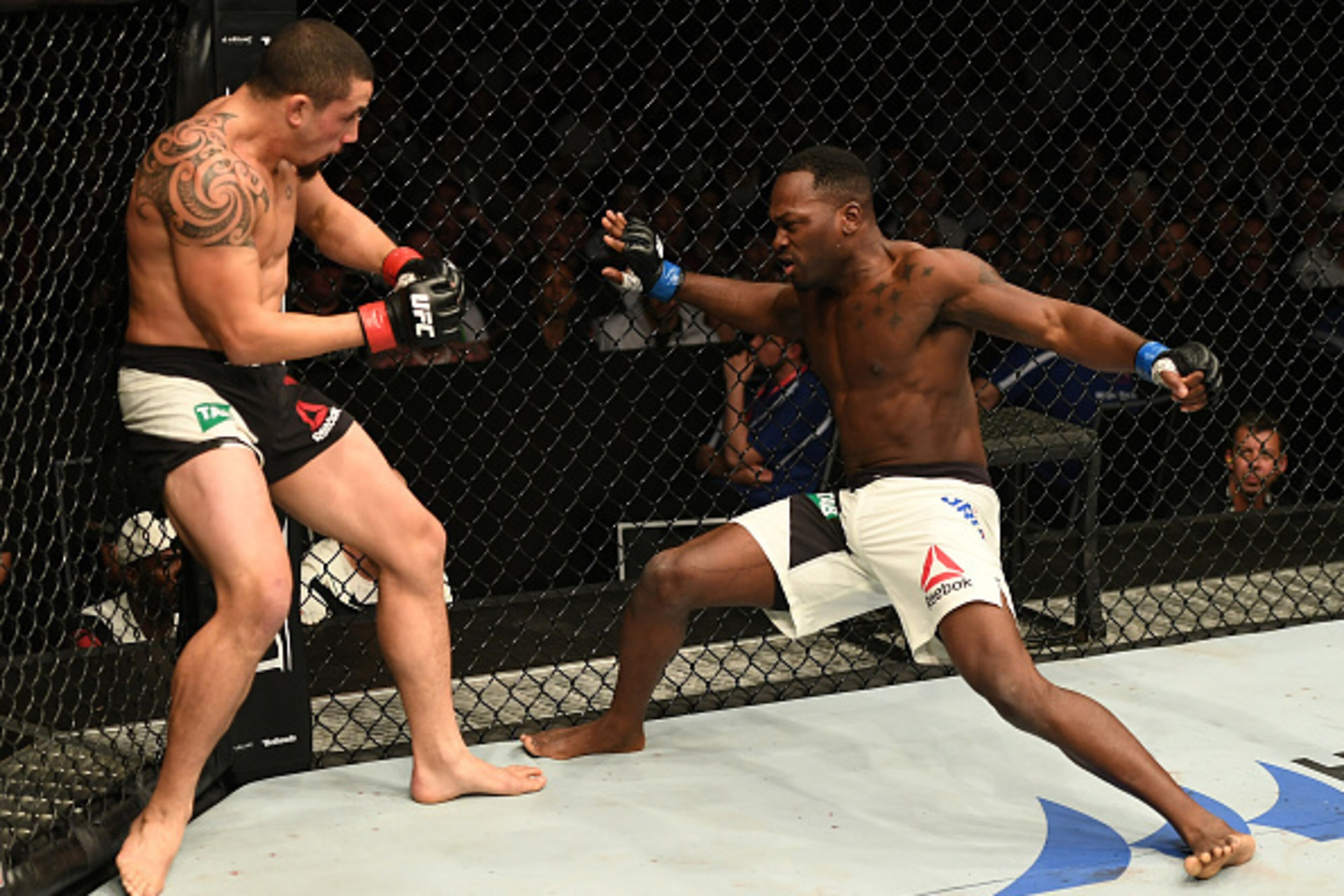 MELBOURNE, AUSTRALIA - NOVEMBER 27:   (L-R) Robert Whittaker of New Zealand stuns Derek Brunson with a punch in their middleweight bout during the UFC Fight Night event at Rod Laver Arena on November 27, 2016 in Melbourne, Australia. (Photo by Jeff Bottar