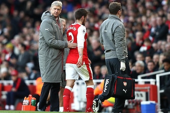LONDON, ENGLAND - NOVEMBER 27: Arsene Wenger, Manager of Arsenal (L) pats Mathieu Debuchy of Arsenal on the back after he is forced off the pitch due to injury during the Premier League match between Arsenal and AFC Bournemouth at Emirates Stadium on Nove