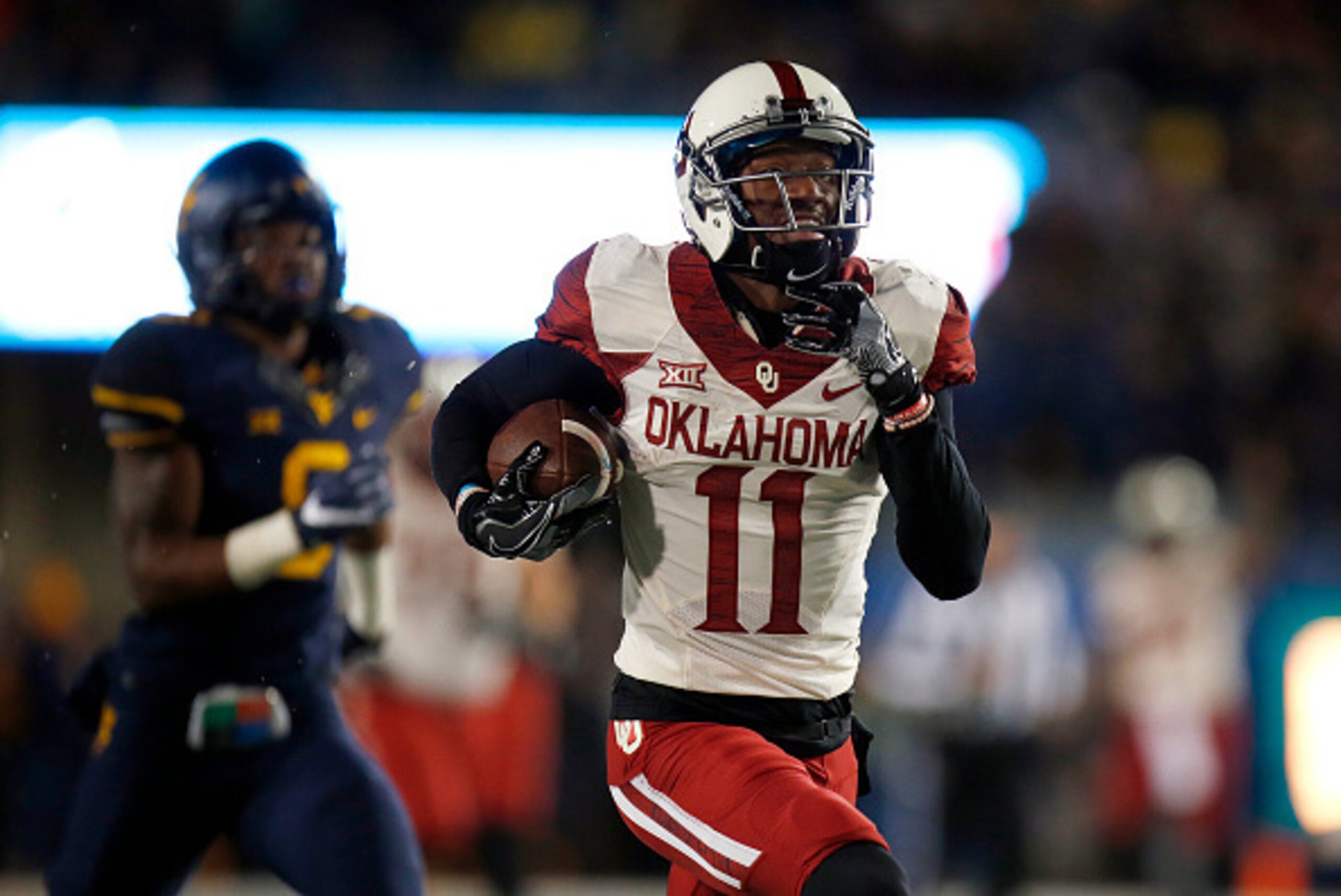 MORGANTOWN, WV - NOVEMBER 19: Dede Westbrook #11 of the Oklahoma Sooners scores on a 75 yard touchdown pass in the first half against the West Virginia Mountaineers on November 19, 2016 at Mountaineer Field in Morgantown, West Virginia. (Photo by Justin MORGANTOWN, WV - NOVEMBER 19: Dede Westbrook #11 of the Oklahoma Sooners scores on a 75 yard touchdown pass in the first half against the West Virginia Mountaineers on November 19, 2016 at Mountaineer Field in Morgantown, West Virginia. (Photo by Justin