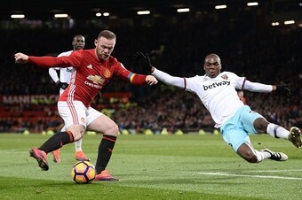 West Ham United's Italian defender Angelo Ogbonna (R) launches himself to try to defend against Manchester United's English striker Wayne Rooney (L) during the English Premier League football match between Manchester United and West Ham United at Old Traf