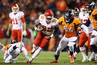 DENVER, CO - NOVEMBER 27:  Running back Spencer Ware #32 of the Kansas City Chiefs carries the ball in the first quarter of the game before being tackled by inside linebacker Brandon Marshall #54 of the Denver Broncos at Sports Authority Field at Mile Hig