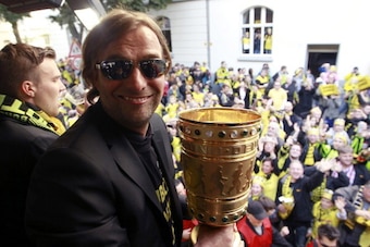 Dortmund's head coach Juergen Klopp holds the German cup ' DFB Pokal '  during a parade through the streets of Dortmund, western Germany, on May 13, 2012. Bundesliga champions Borussia Dortmund blasted Champions League finalists Bayern Munich 5-2 in Satur