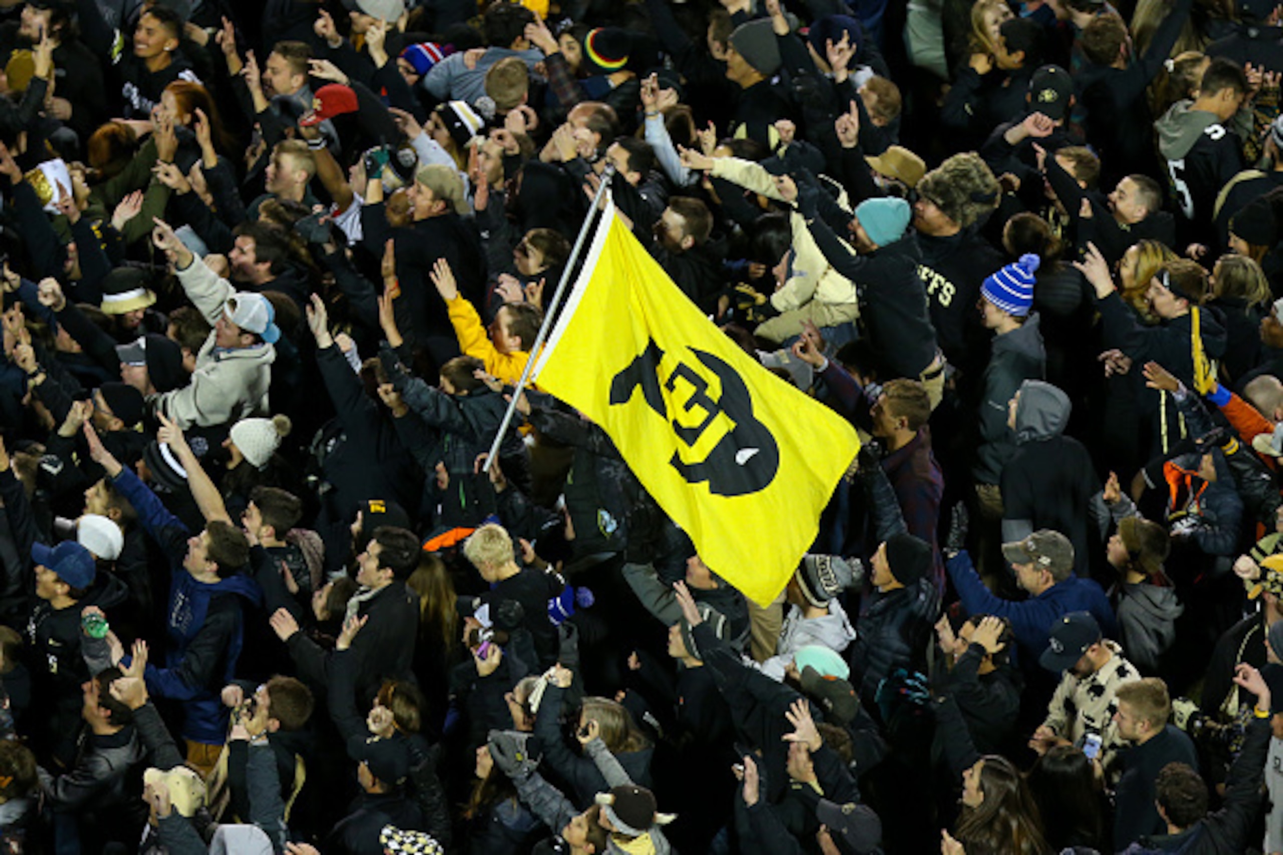 BOULDER, CO - NOVEMBER 26:  Students celebrate on the field with a school flag after their Colorado Buffaloes defeated the Utah Utes 27-22 at Folsom Field on November 26, 2016 in Boulder, Colorado. Colorado won the Pac-12 South. The Buffaloes will play Wa