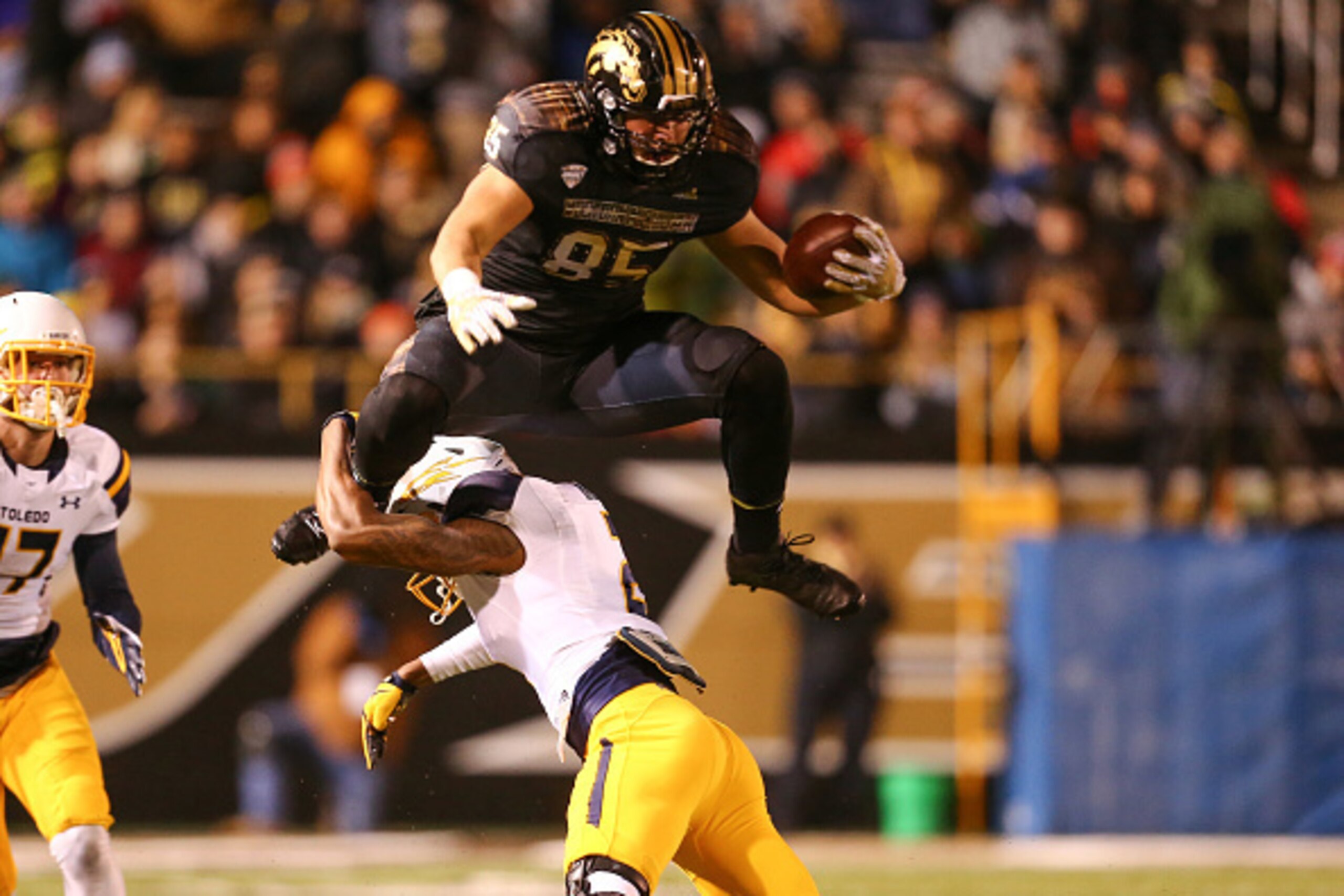 KALAMAZOO, MI - NOVEMBER 25:  Donnie Ernsberger #85 of the Western Michigan Broncos leaps over a Toledo Rockets defender in the second quarter at Waldo Stadium on November 25, 2016 in Kalamazoo, Michigan. (Photo by Rey Del Rio/Getty Images)