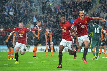 HULL, ENGLAND - AUGUST 27: Marcus Rashford of Manchester United (C) celebrates scoring his sides first goal with his team mates Wayne Rooney of Manchester United (L) and Zlatan Ibrahimovic of Manchester United (R) during the Premier League match between H