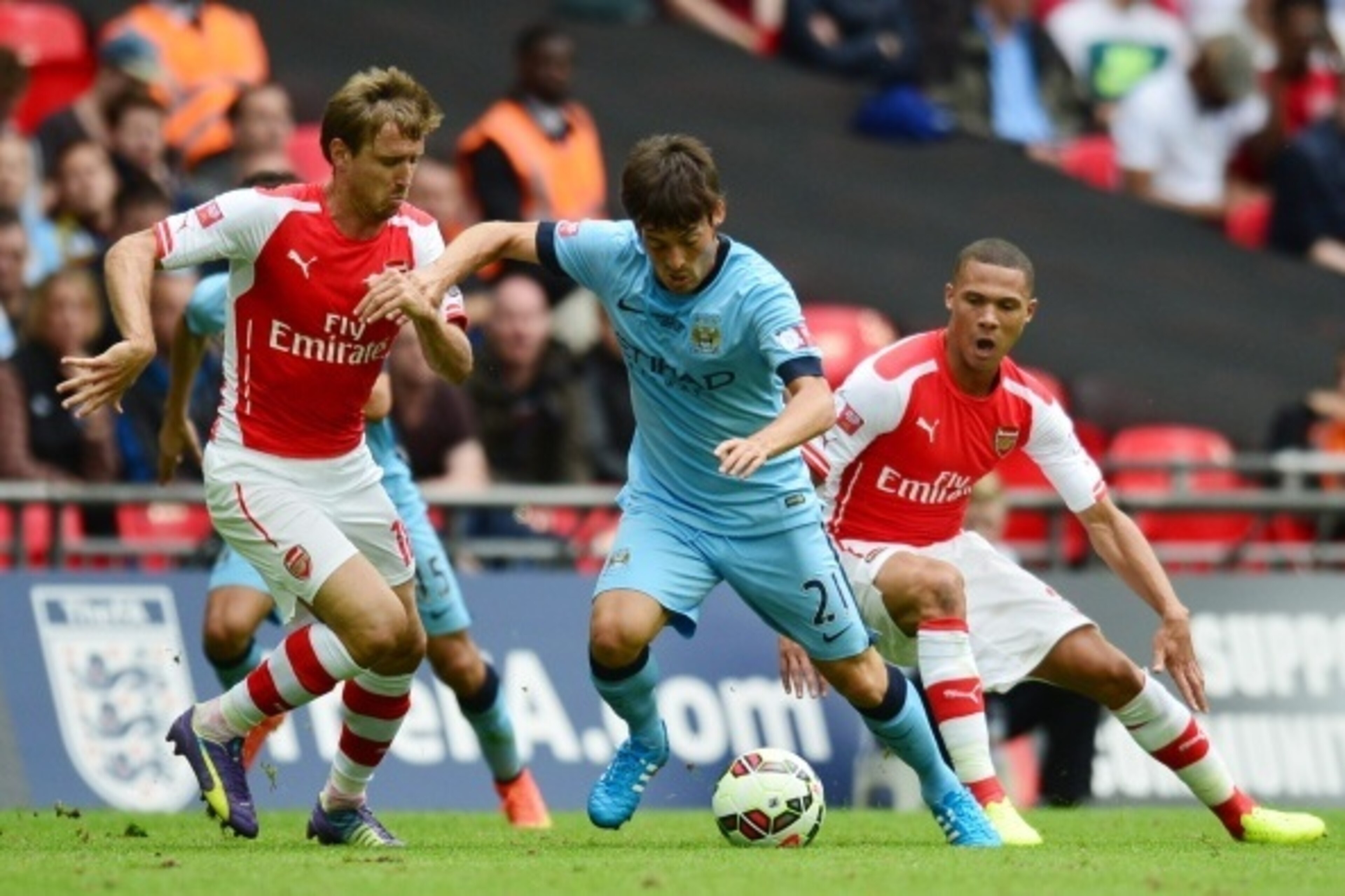 Manchester City's Spanish midfielder David Silva (C) runs with the ball between Arsenal's Spanish defender Nacho Monreal (L) and Arsenal's English defender Kieran Gibbs (R) during the FA Community Shield football match between Arsenal and Manchester City 