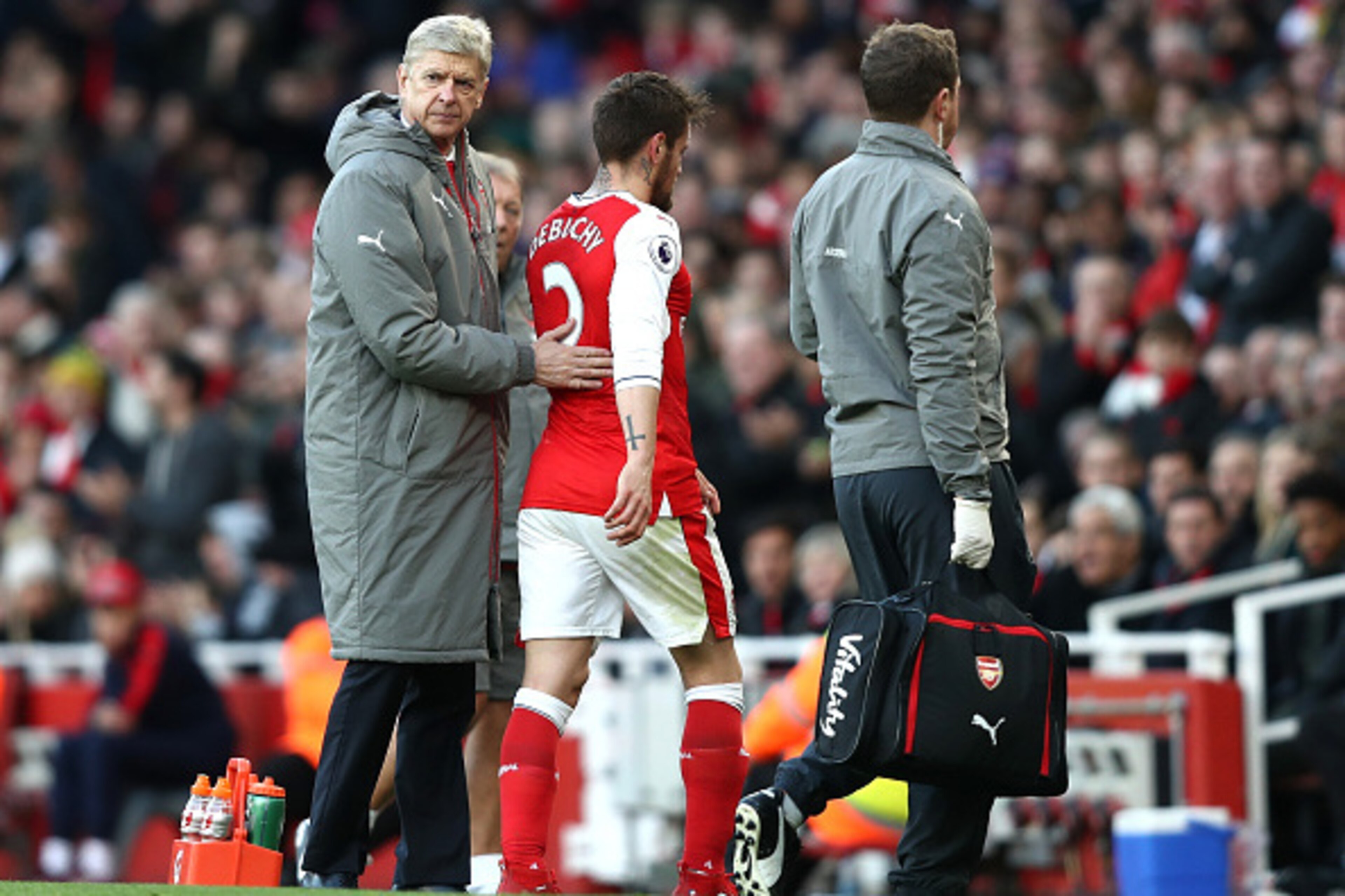 LONDON, ENGLAND - NOVEMBER 27: Arsene Wenger, Manager of Arsenal (L) pats Mathieu Debuchy of Arsenal on the back after he is forced off the pitch due to injury during the Premier League match between Arsenal and AFC Bournemouth at Emirates Stadium on Nove