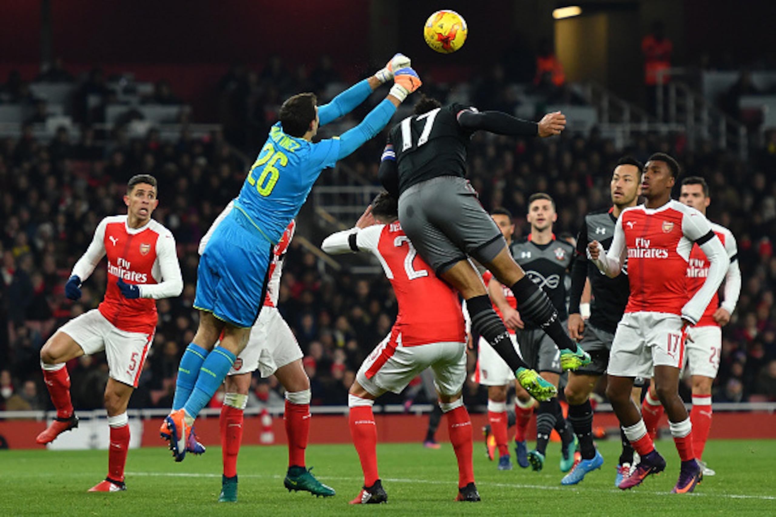 LONDON, ENGLAND - NOVEMBER 30: Emiliano Martinez of Arsenal punches cleae under pressure from Virgil van Dijk of Southampton during the EFL Cup quarter final match between Arsenal and Southampton at the Emirates Stadium on November 30, 2016 in London, Eng