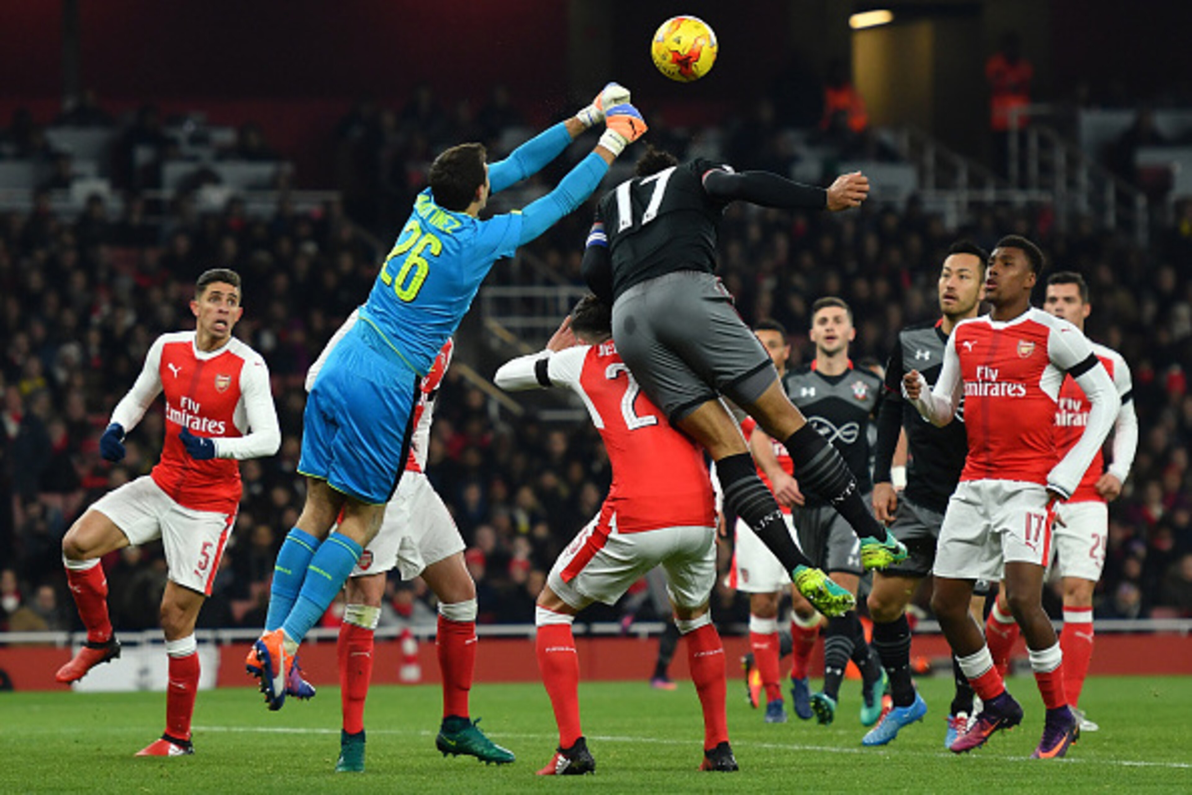 LONDON, ENGLAND - NOVEMBER 30: Emiliano Martinez of Arsenal punches cleae under pressure from Virgil van Dijk of Southampton during the EFL Cup quarter final match between Arsenal and Southampton at the Emirates Stadium on November 30, 2016 in London, Eng